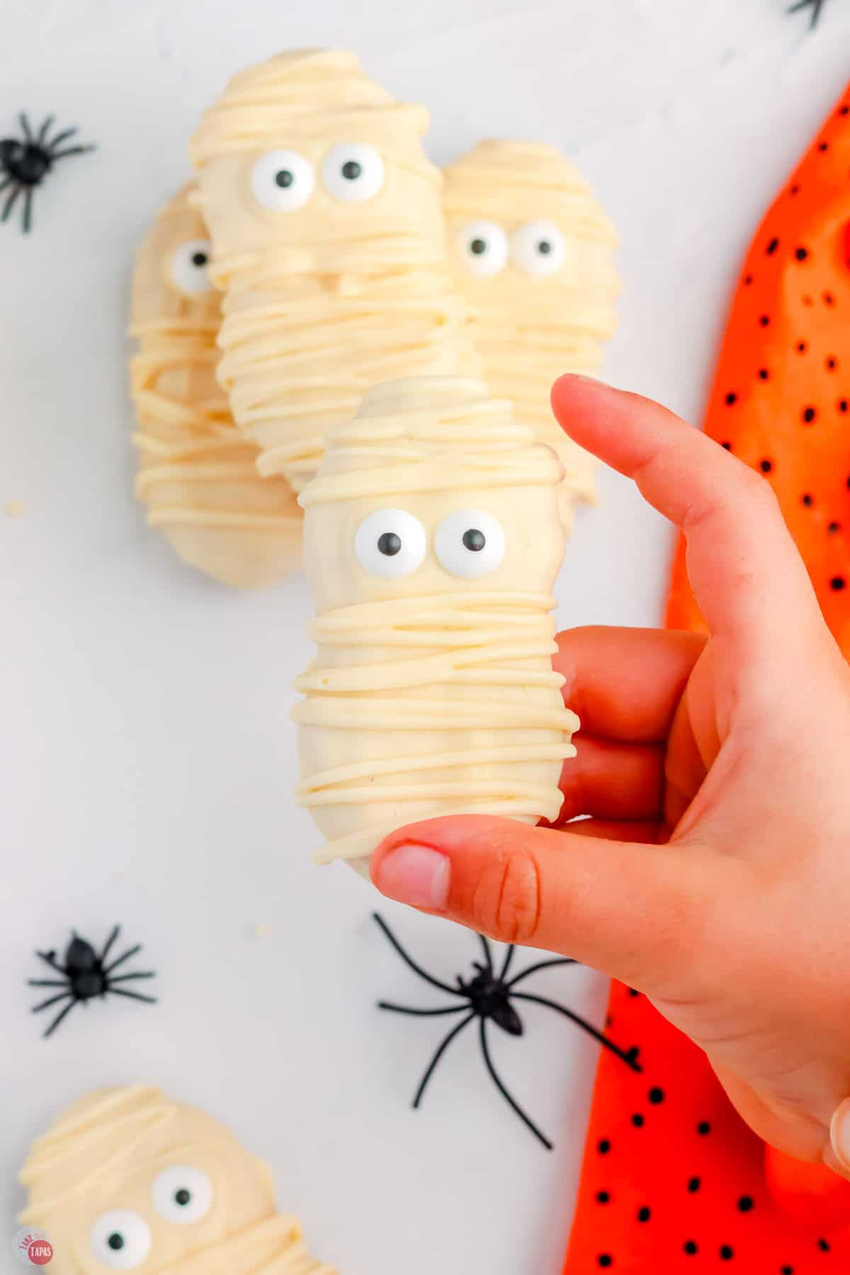 hand holding a mummy cookie with eyes