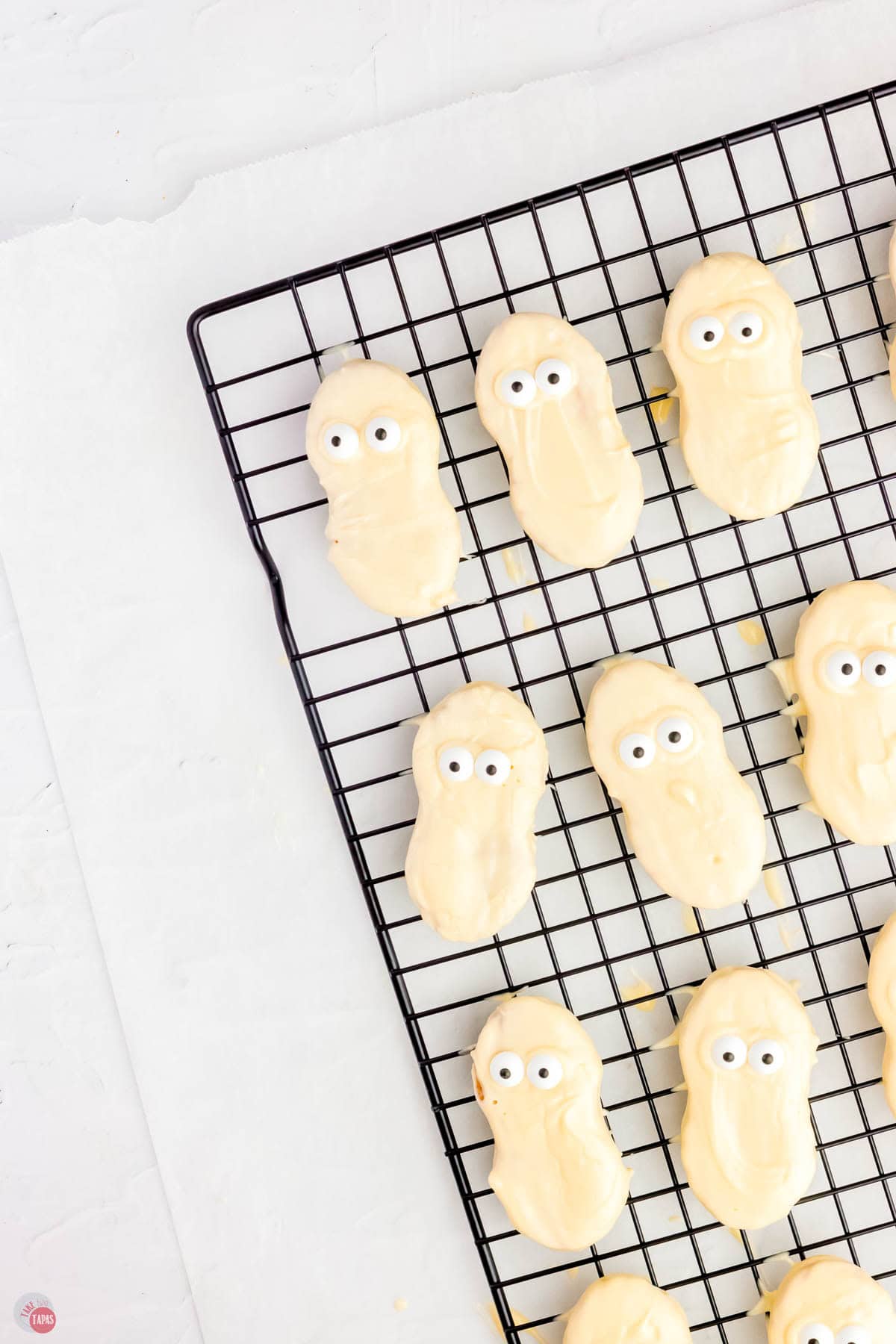 white cookies with eyes on them on a black metal rack