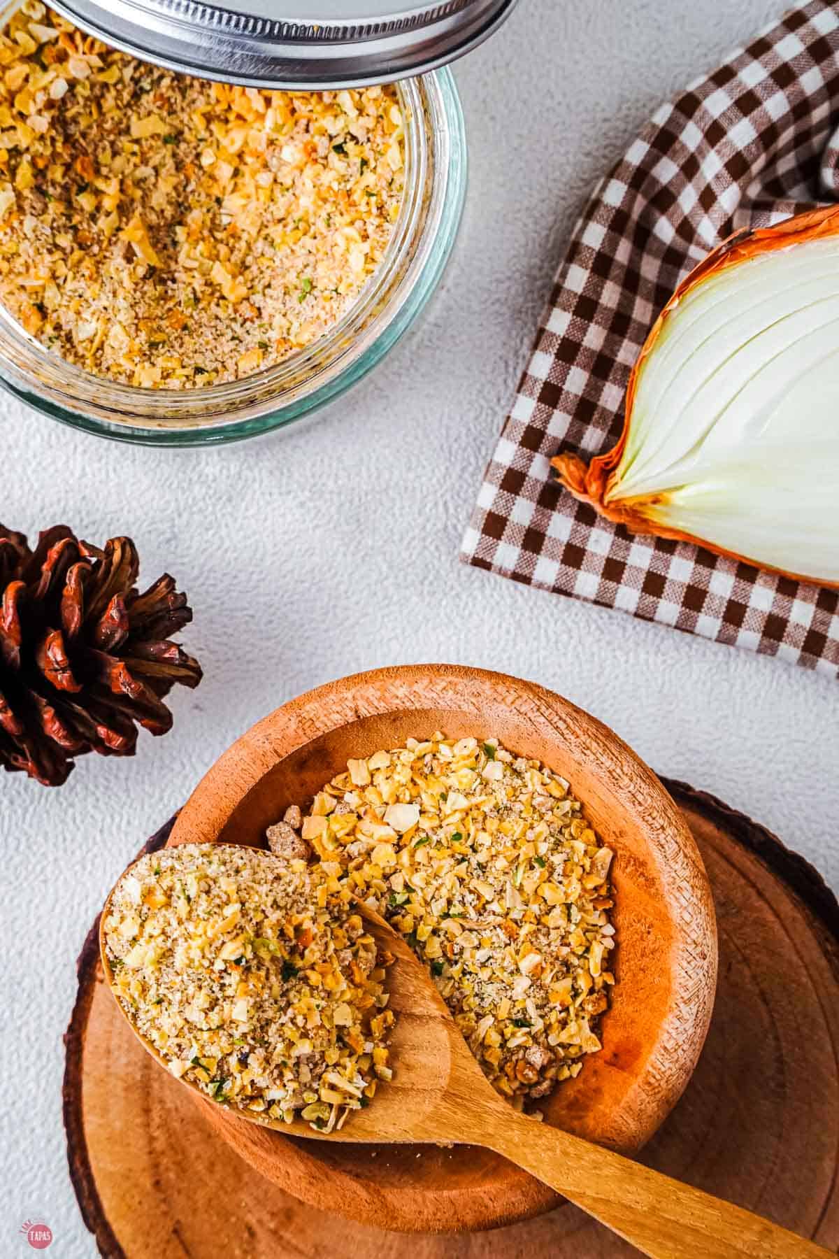 wood bowl with spices in it and a slices onion next to it