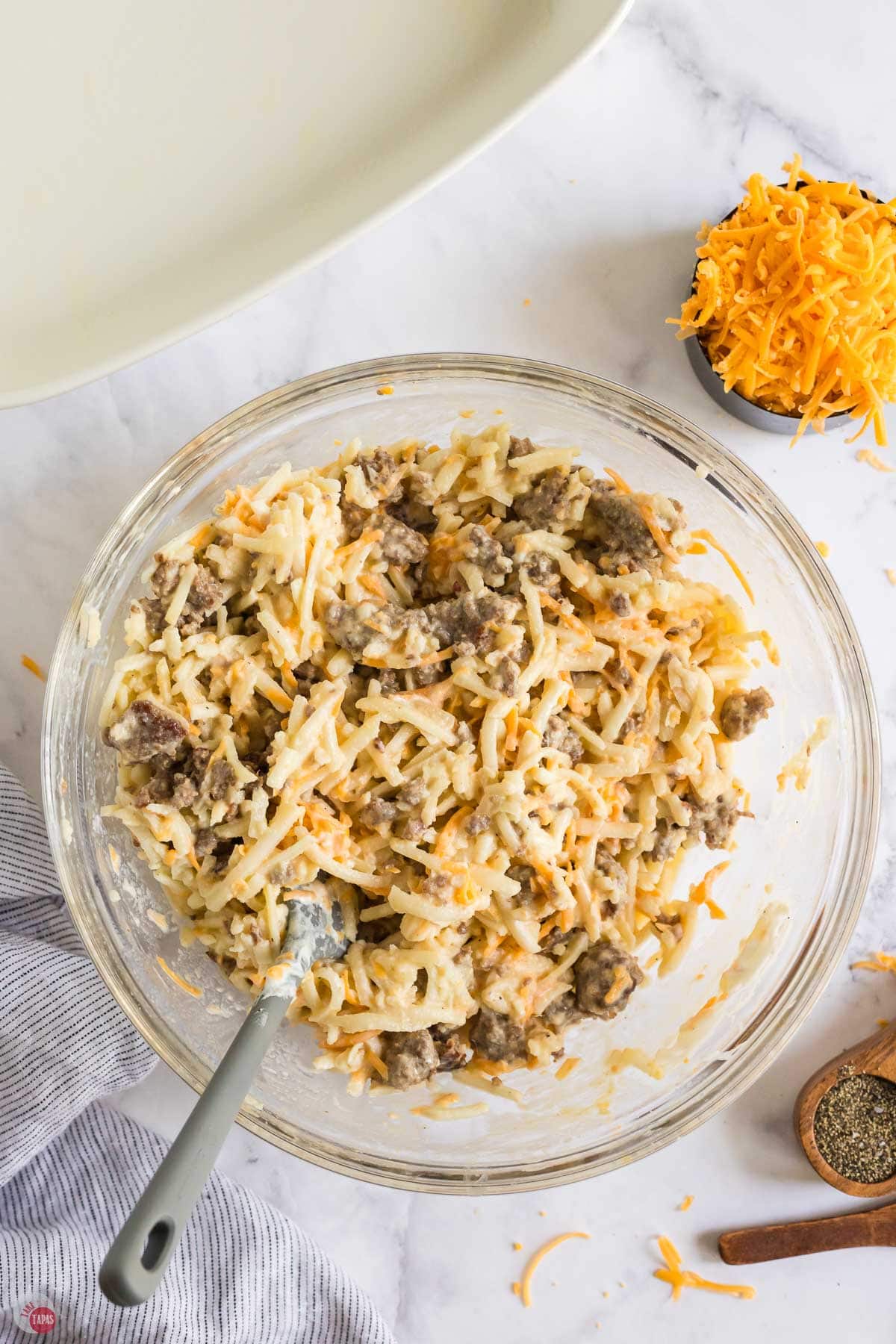 sausage mixture in a clear bowl with a spatula