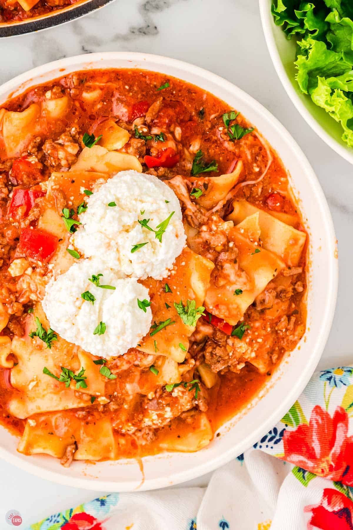 close up of soup with two scoops of ricotta cheese on it