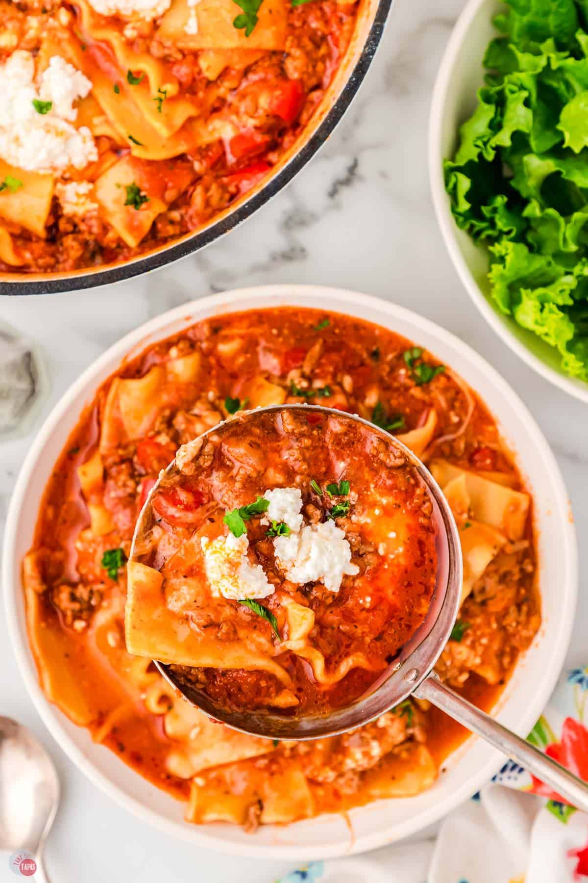 close up of ladle with pasta soup in it