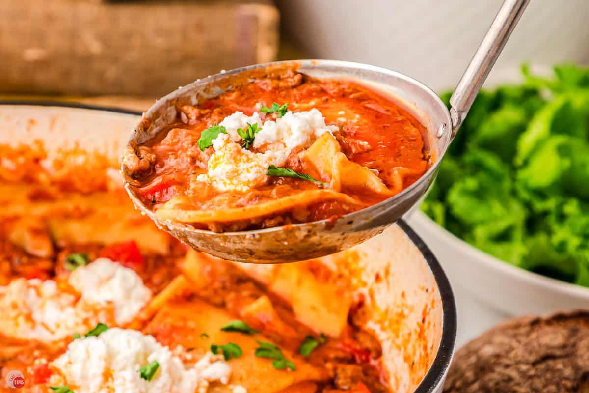 ladle of soup with cheese and noodles