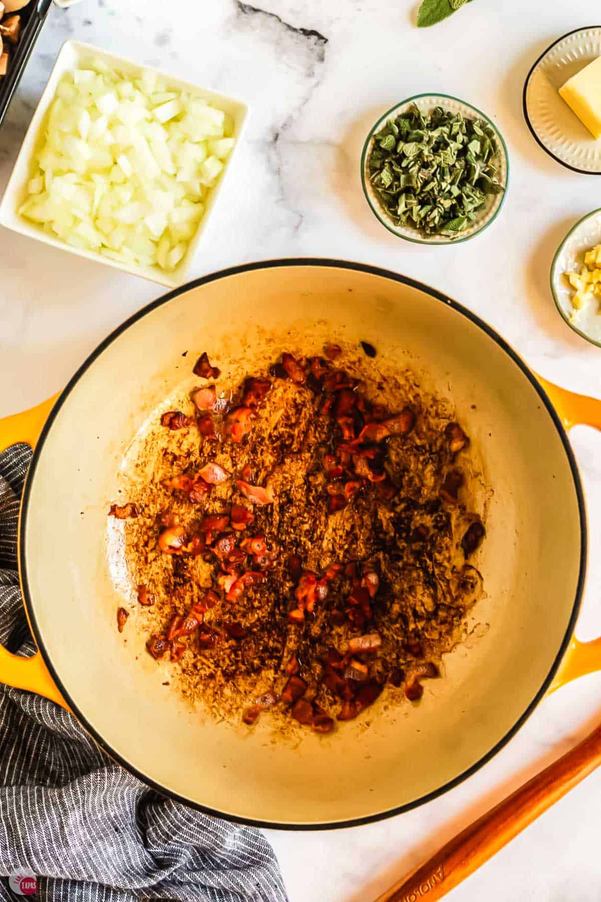 bacon pieces cooking in a yellow pot