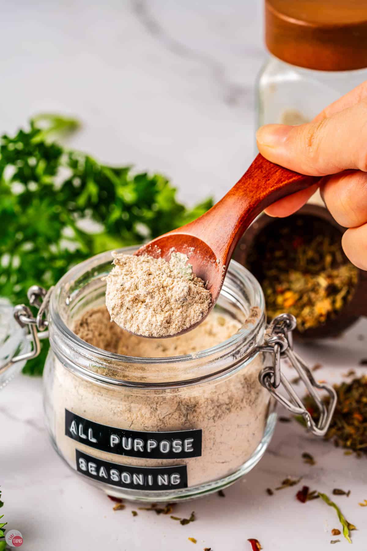 jar of seasoning with a hand scooping some out