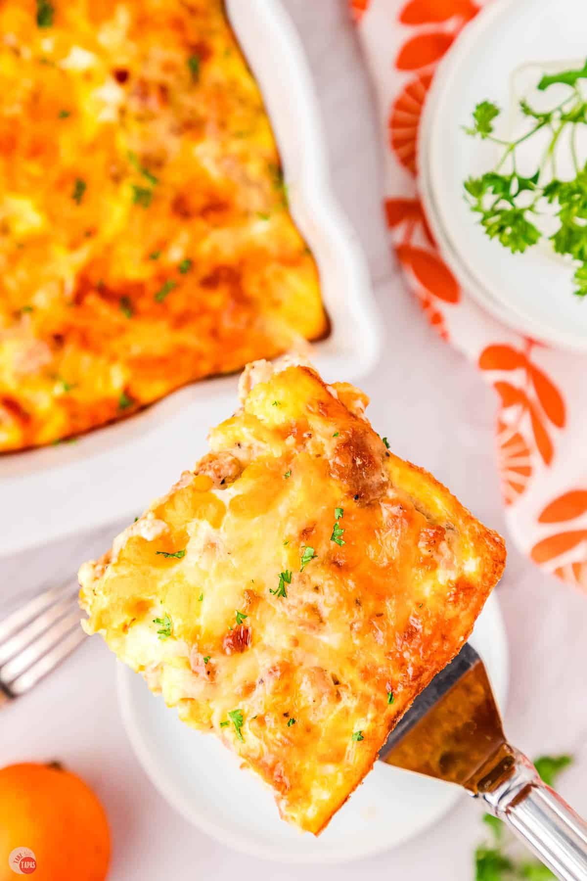 spatula holding a serving of biscuits and gravy casserole