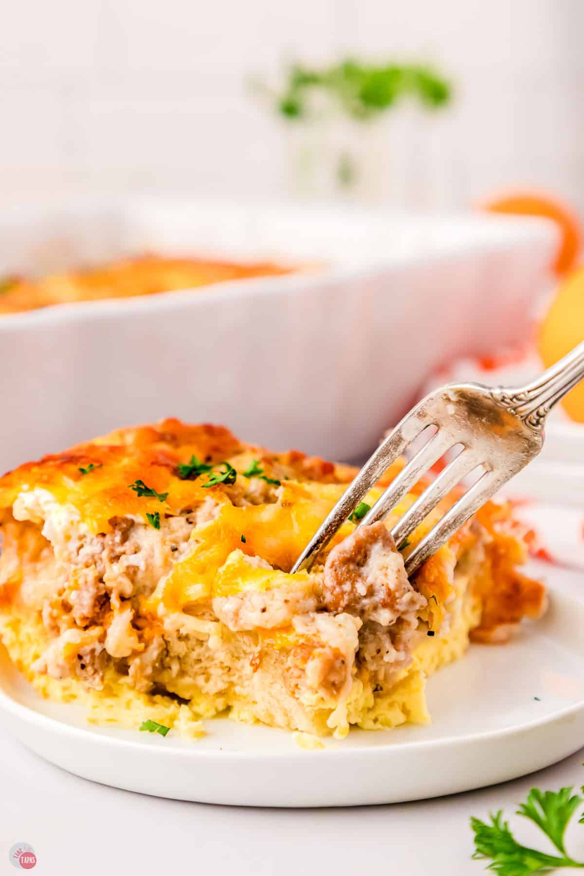 serving of breakfast casserole with fork taking a bite out of it