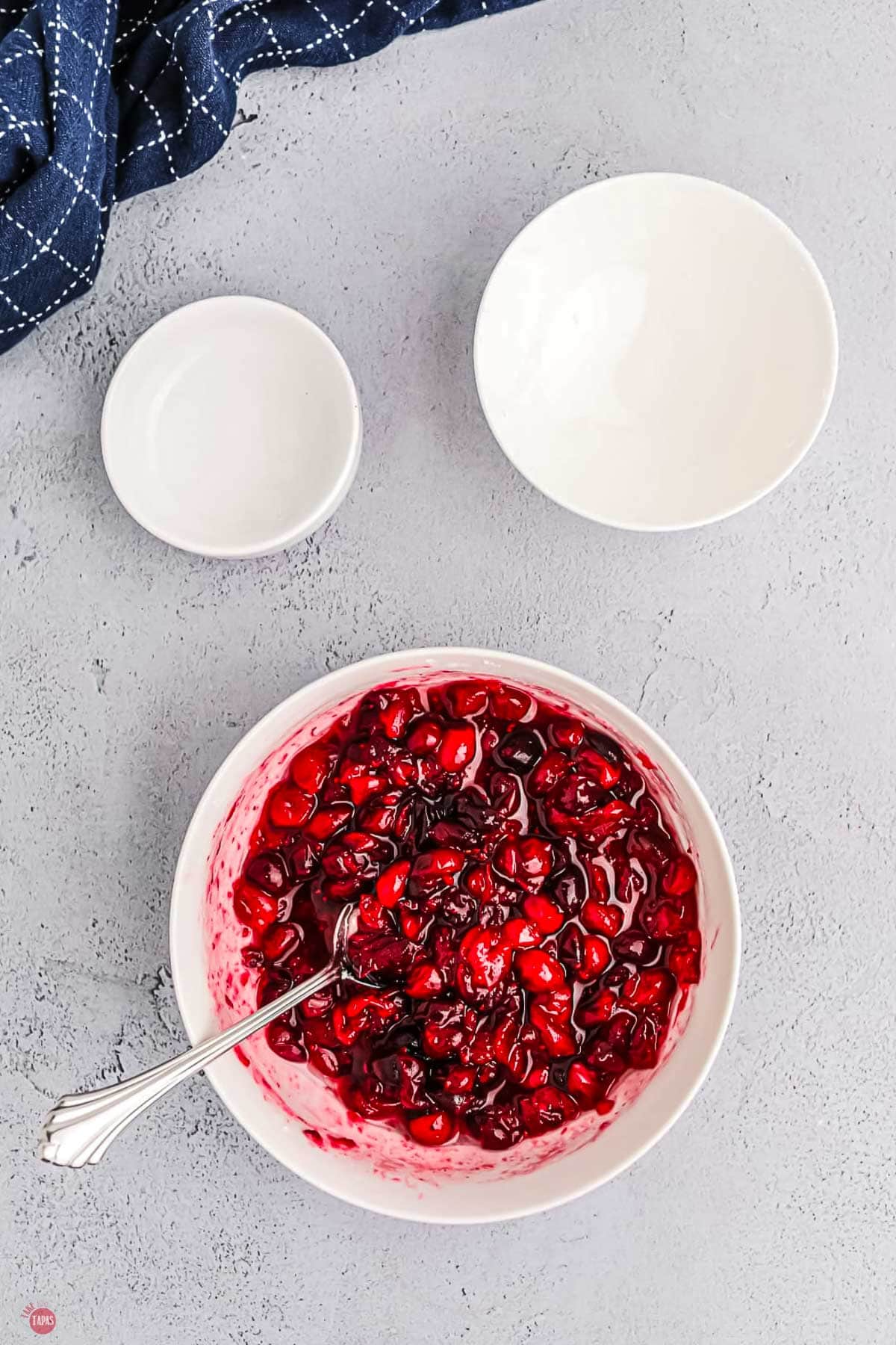 cranberries in a bowl with sugar and a small spoon