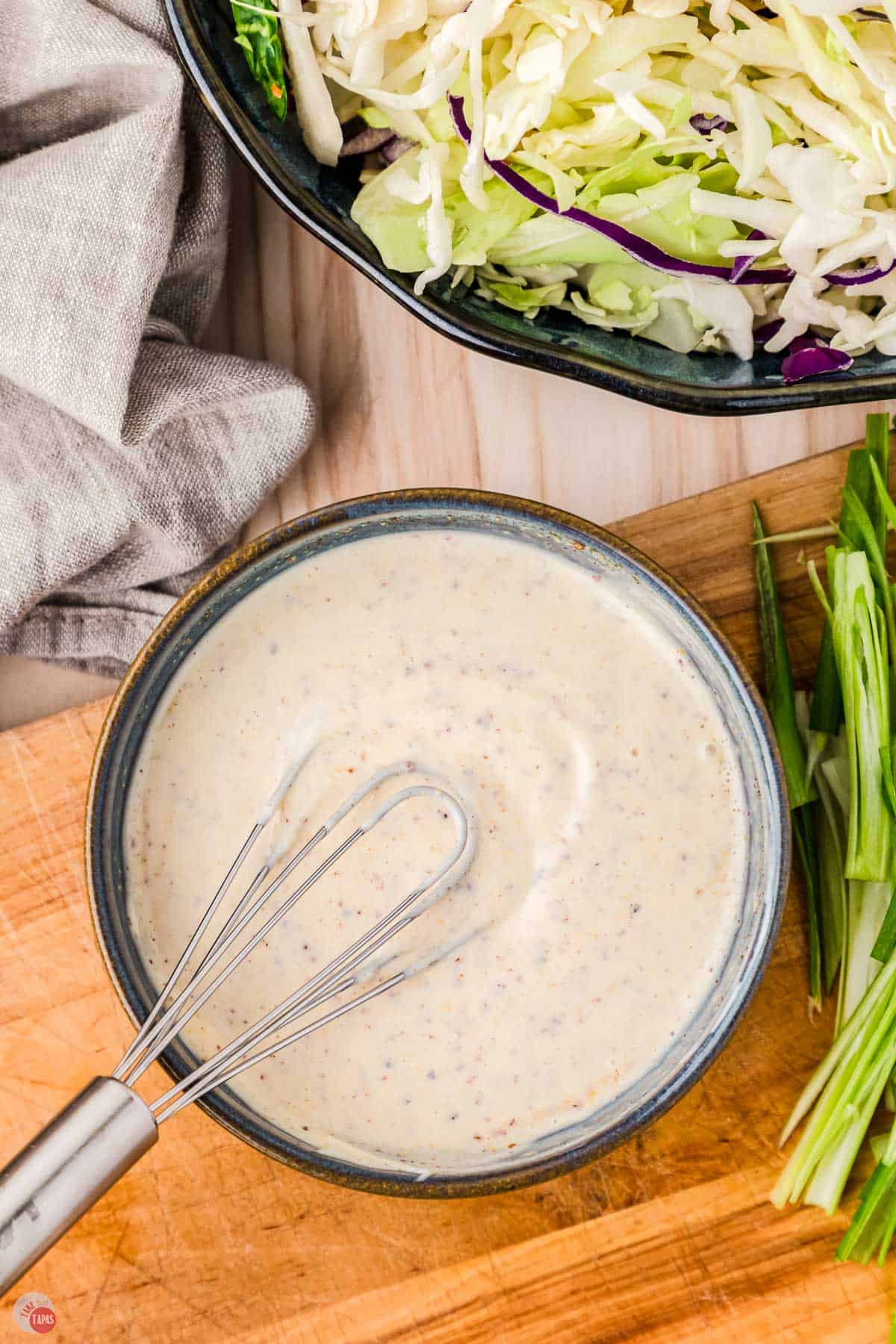 coleslaw dressing in a bowl with a whisk
