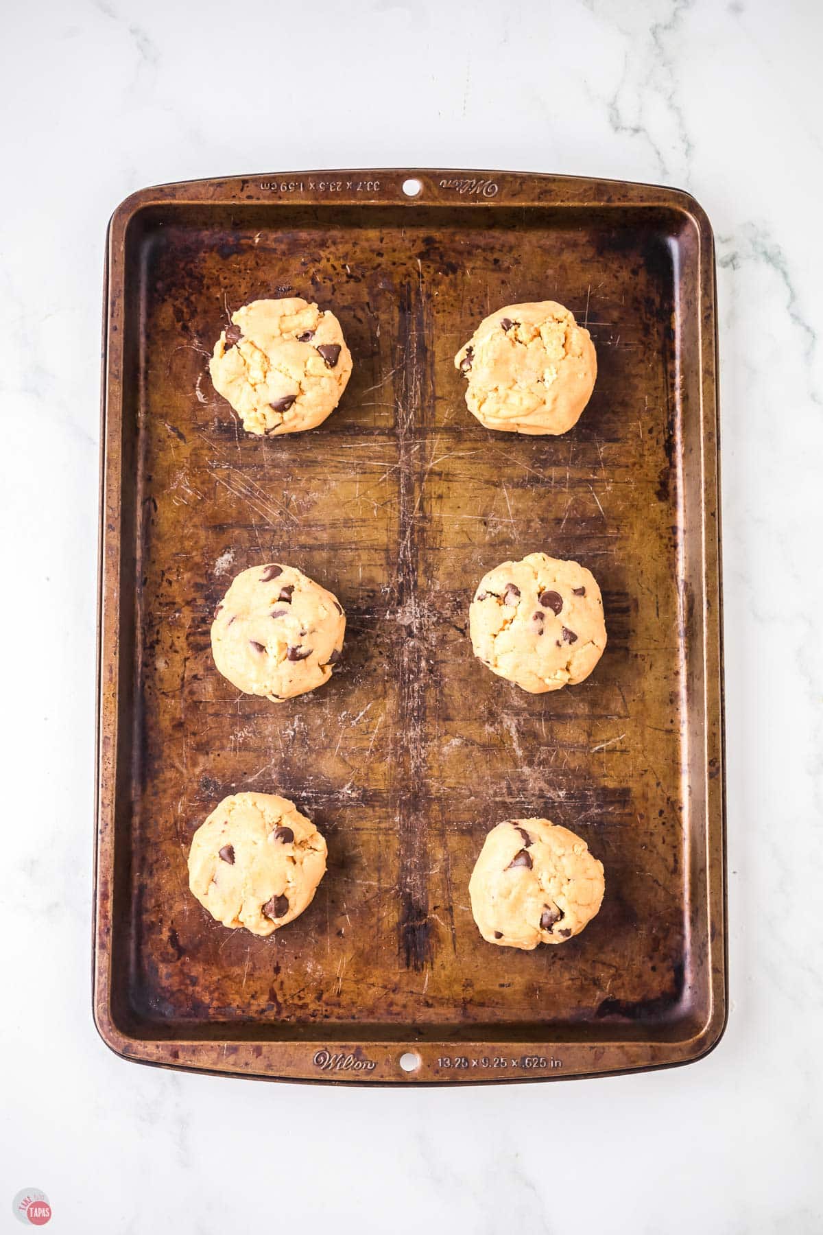 raw cookie dough balls on a baking sheet