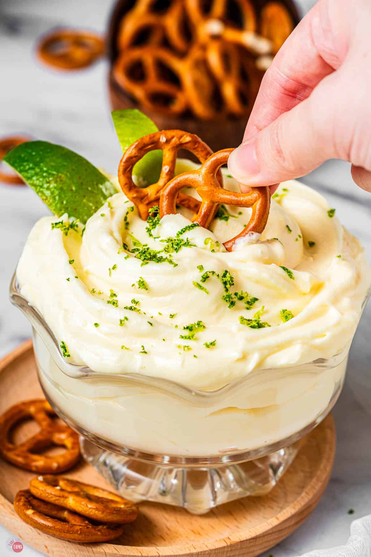 bowl of margarita dip with a pretzel being dipped in it