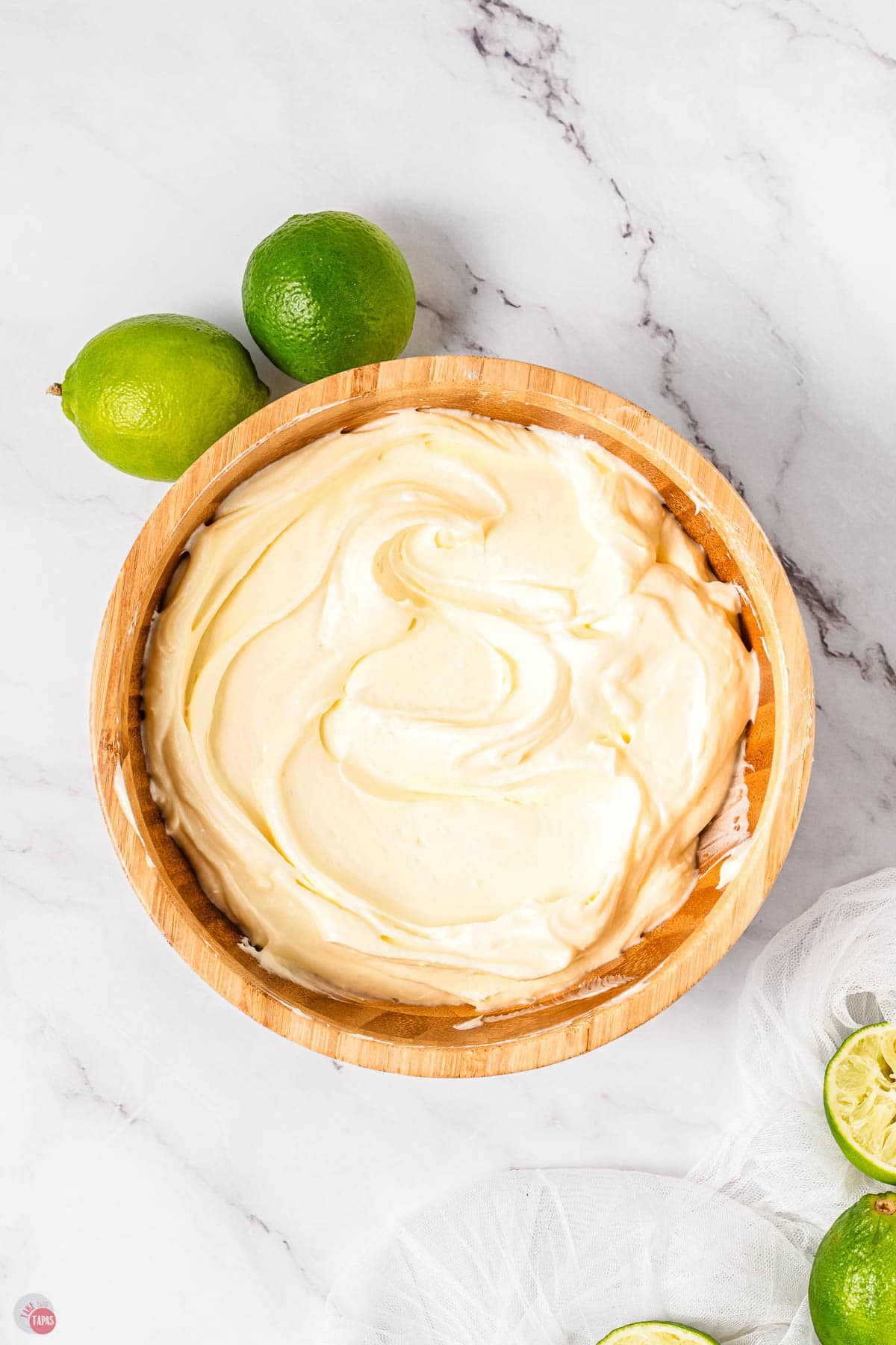 margarita dip in a wood bowl with limes next to it