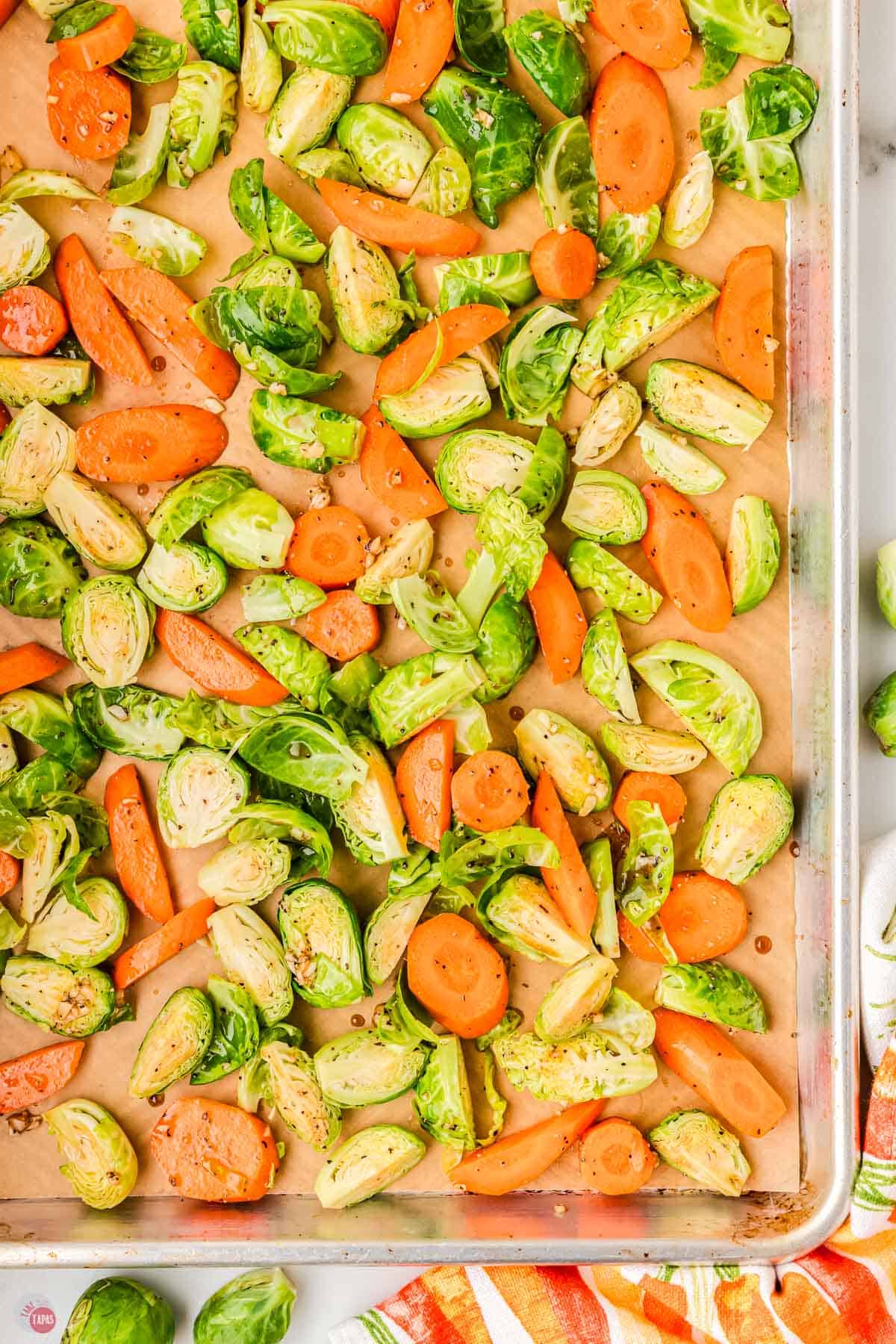 sheet pan with sliced raw vegetables on it