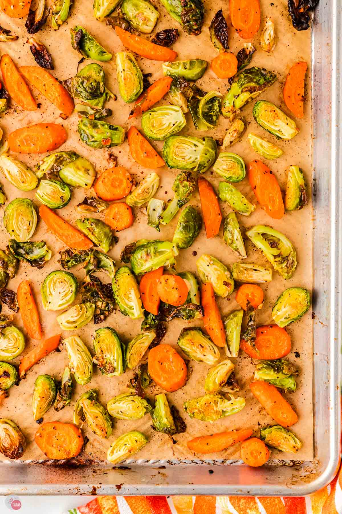 roasted brussels sprouts and carrots on a baking sheet with parchment paper