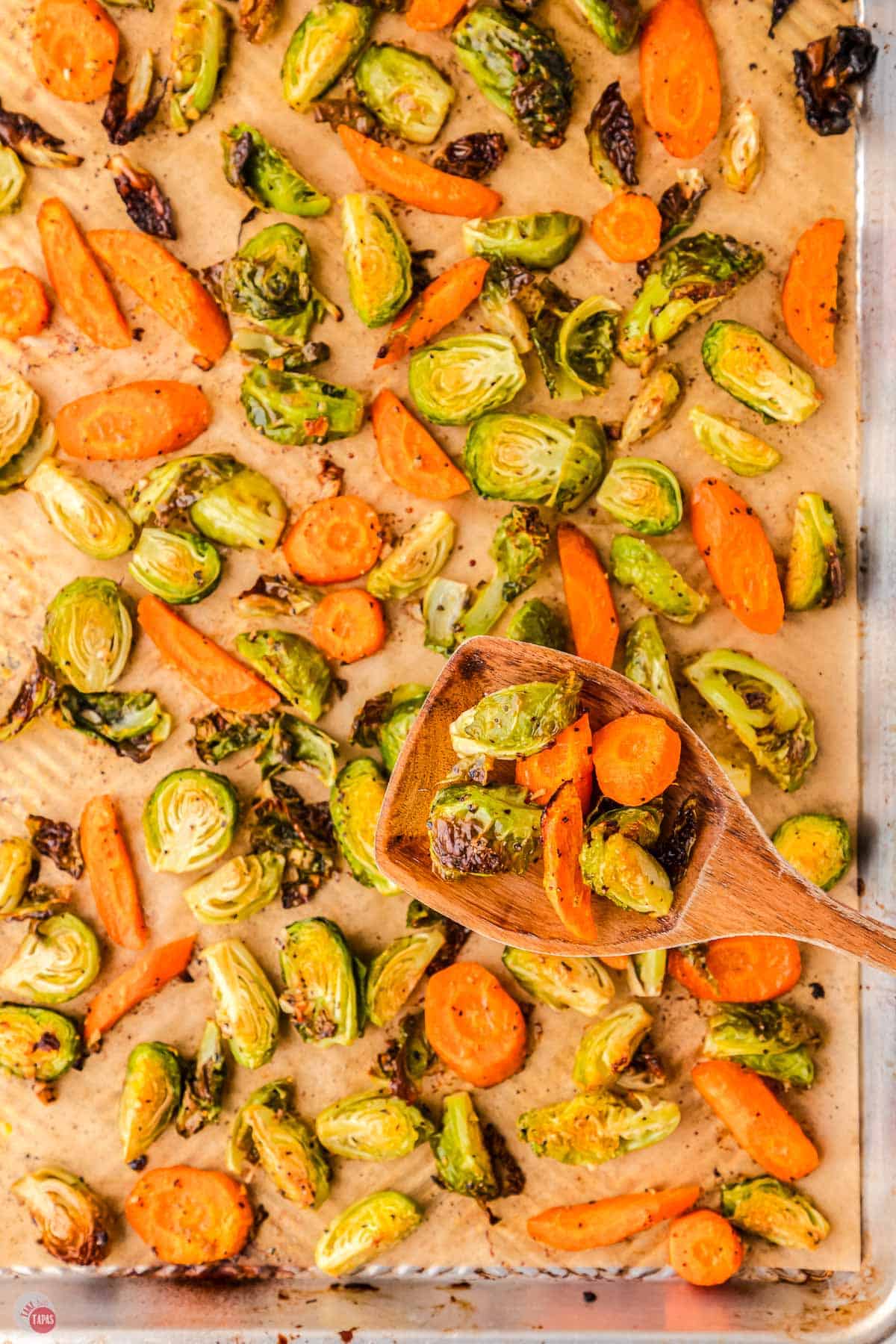 carrots and Brussels sprouts scattered on parchment paper