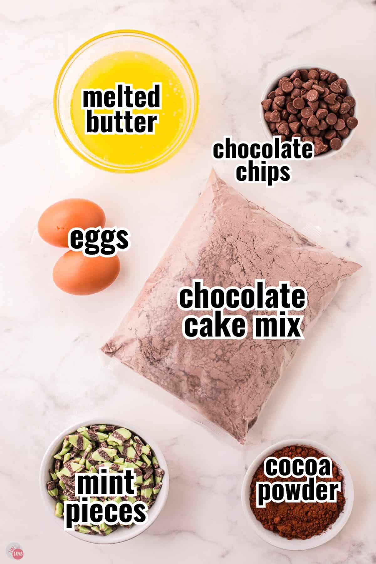 ingredients for a cookie recipe on a marble backdrop with text overlay labeling them