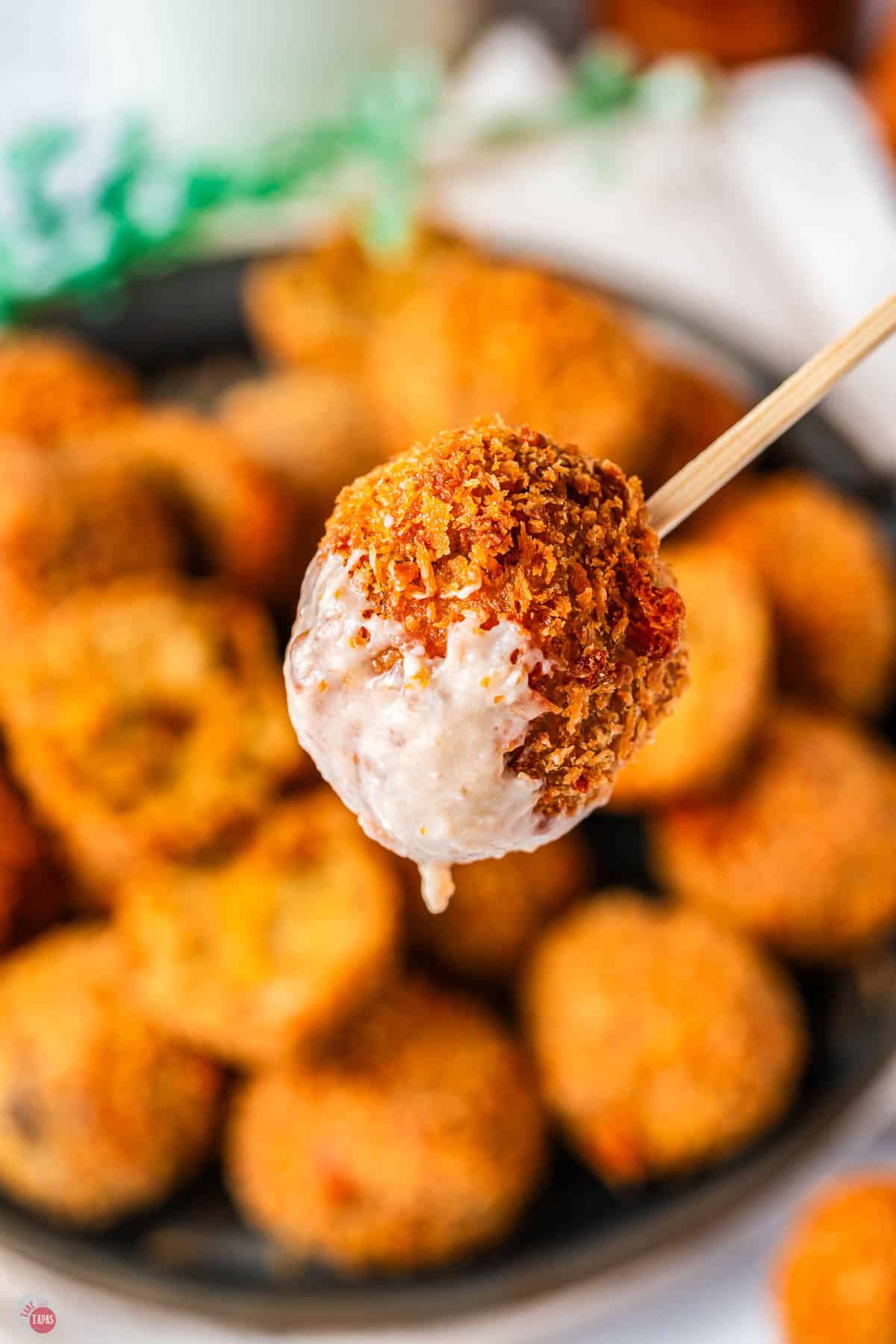 stuffing ball on a toothpick with cranberry dip on the bottom
