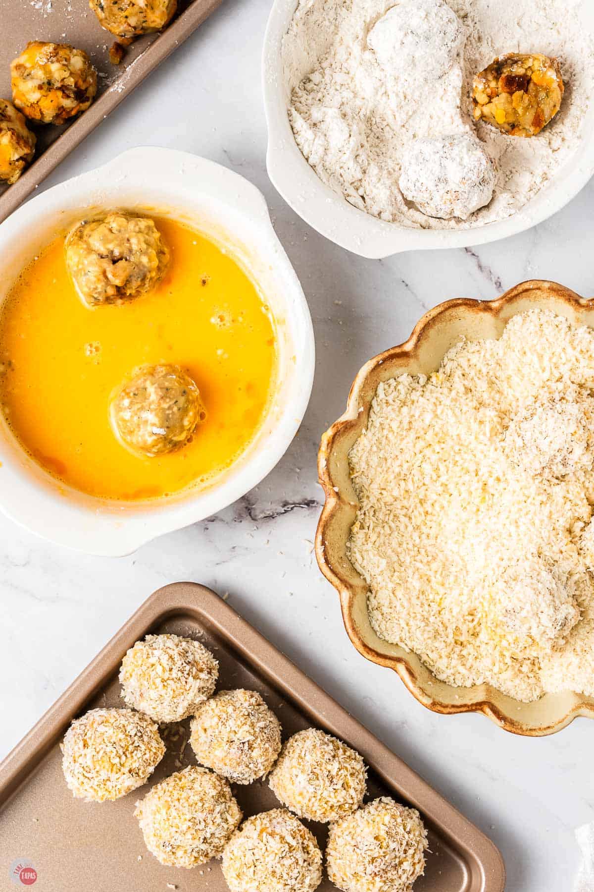 bowls of egg wash, panko coating, and a pan of stuffing