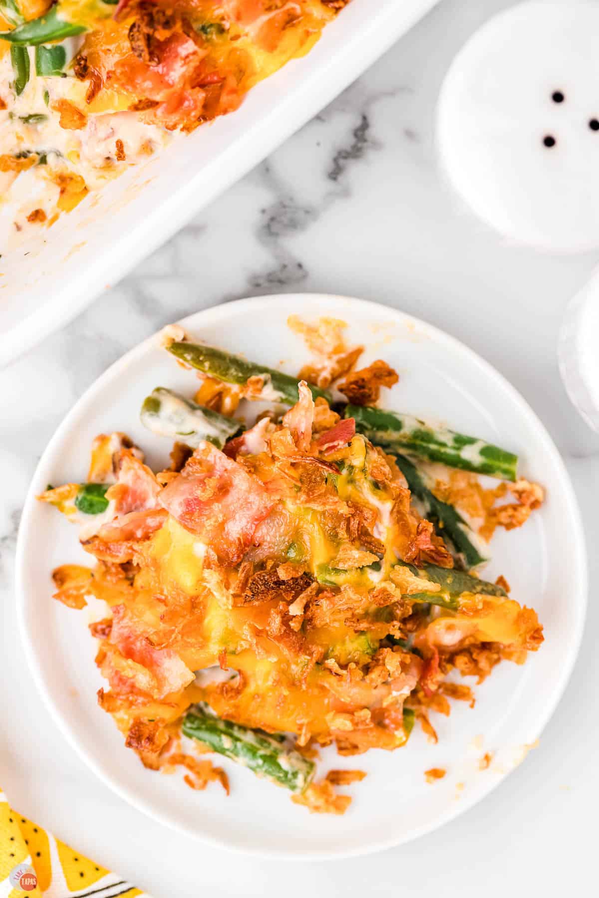plate of crack green bean casserole next to salt and pepper shakers