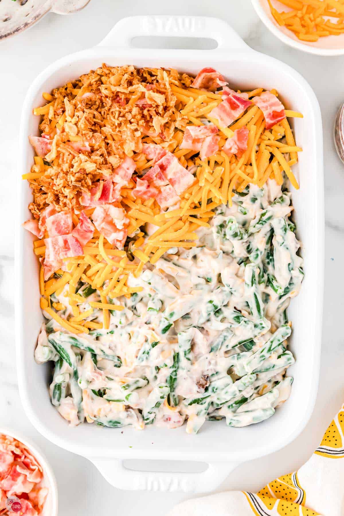 green bean casserole with half layers showing the top ingredients