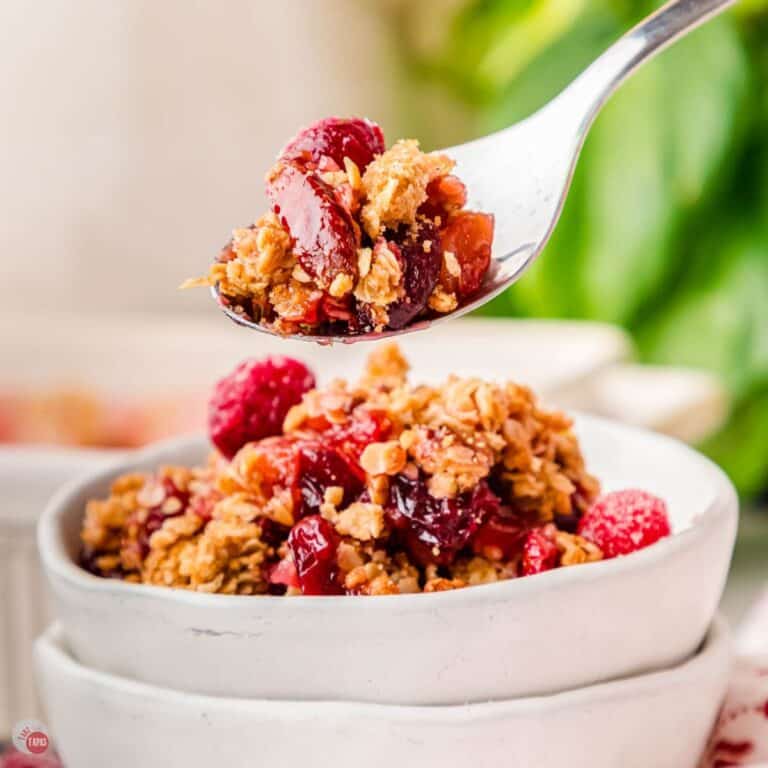 stack of bowls with cranberry casserole in the top one and a spoon