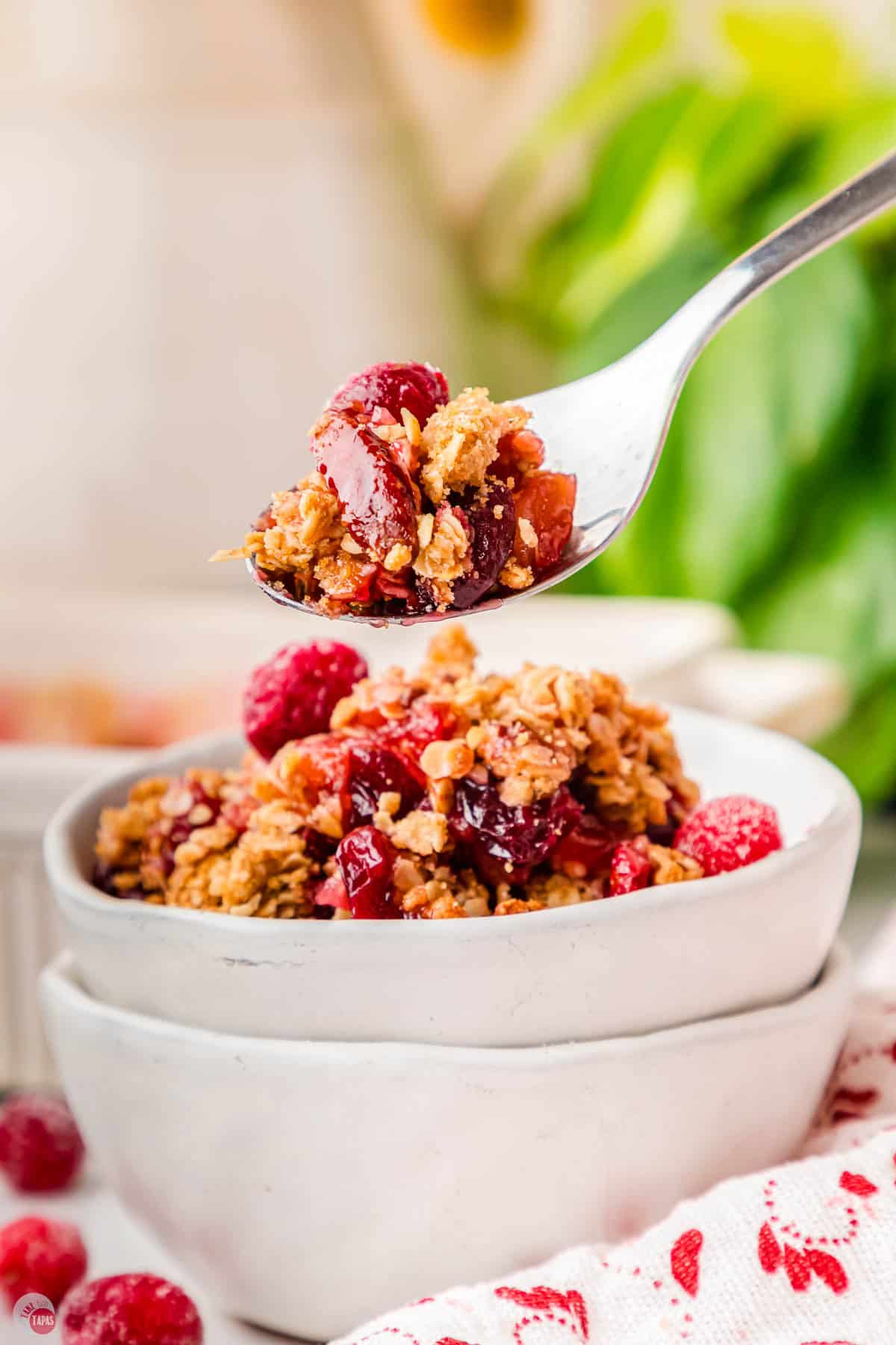 stack of white bowls with the top one filled with cranberries
