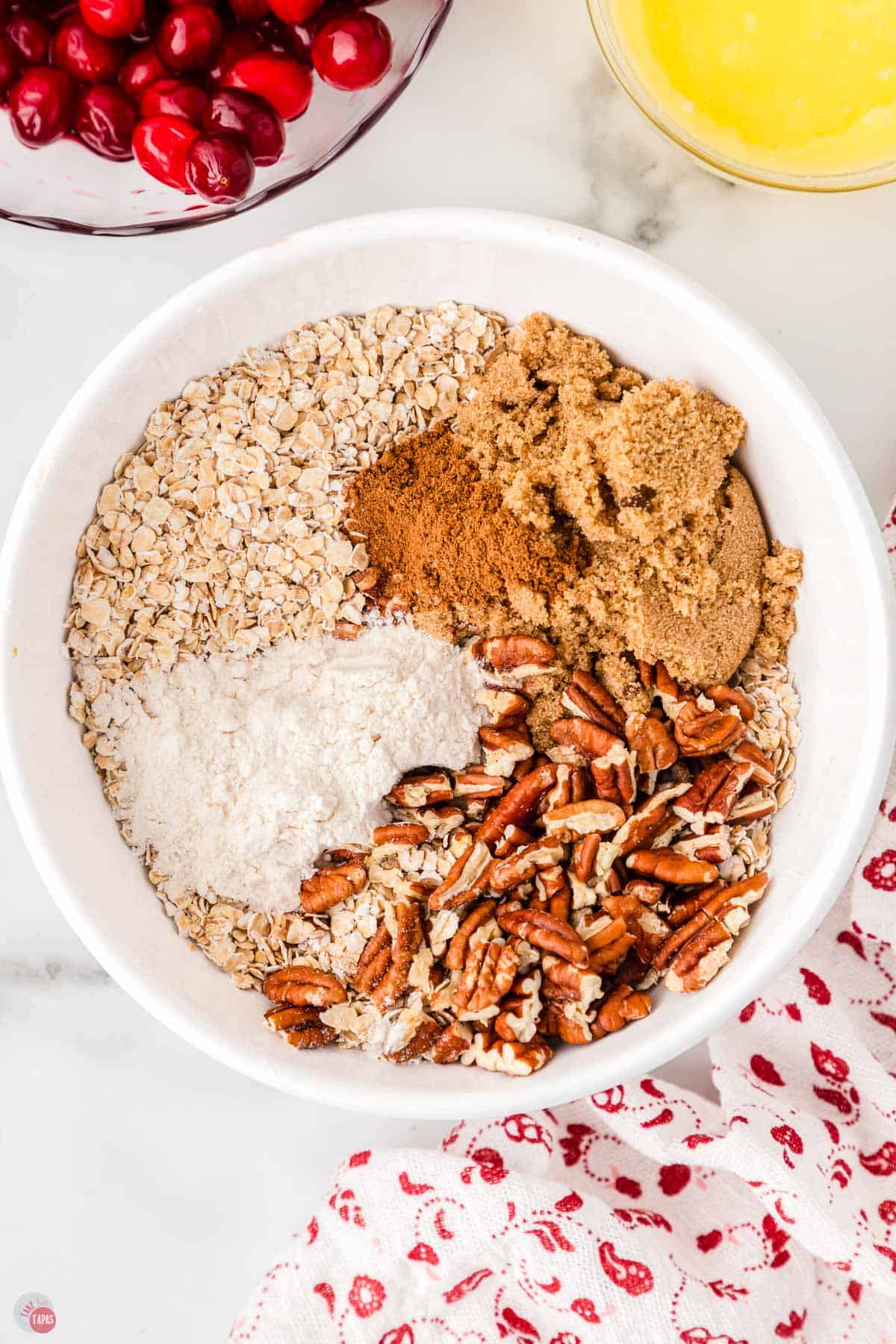 large bowl filled with oatmeal, brown sugar, and pecans