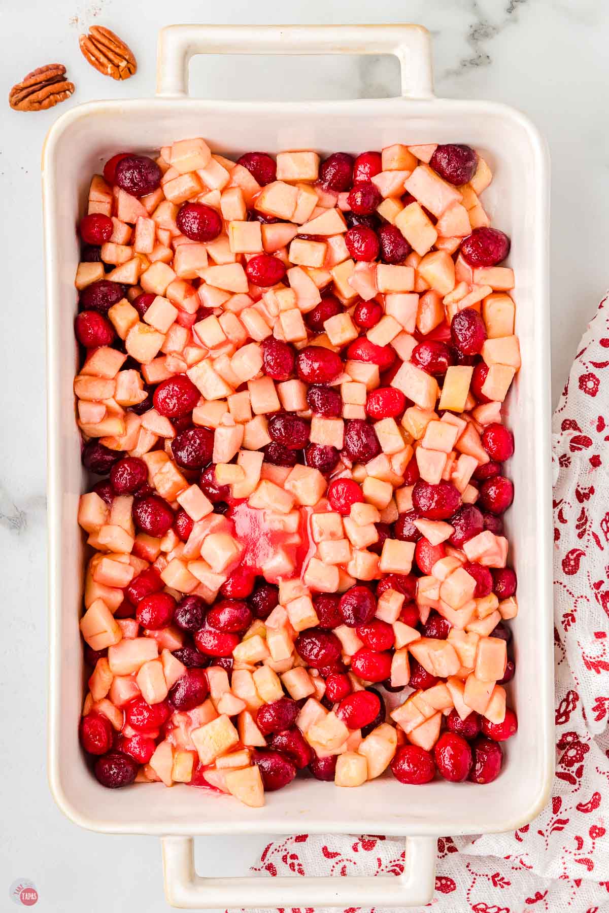 apples and cranberries in a white casserole dish
