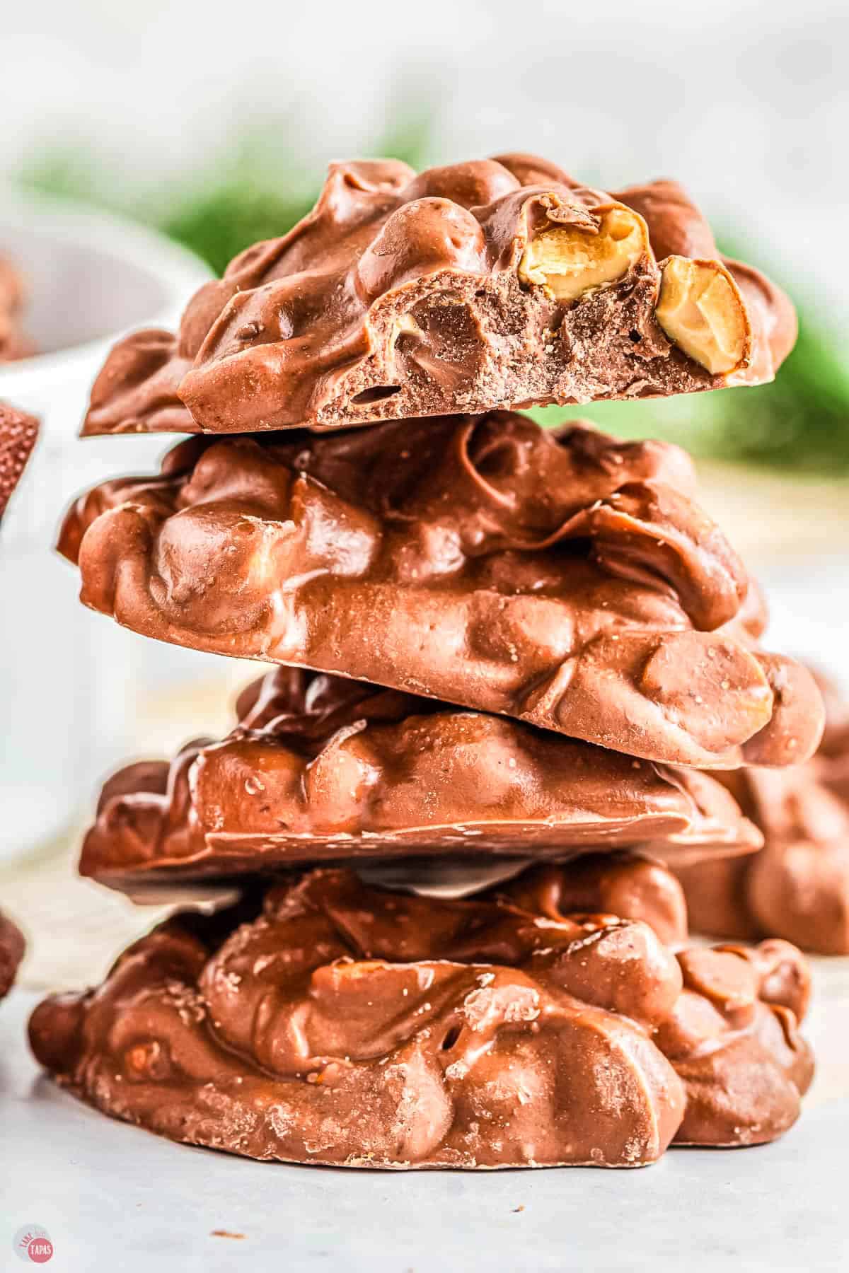 stack of chocolate peanut clusters with a bite out of one of them