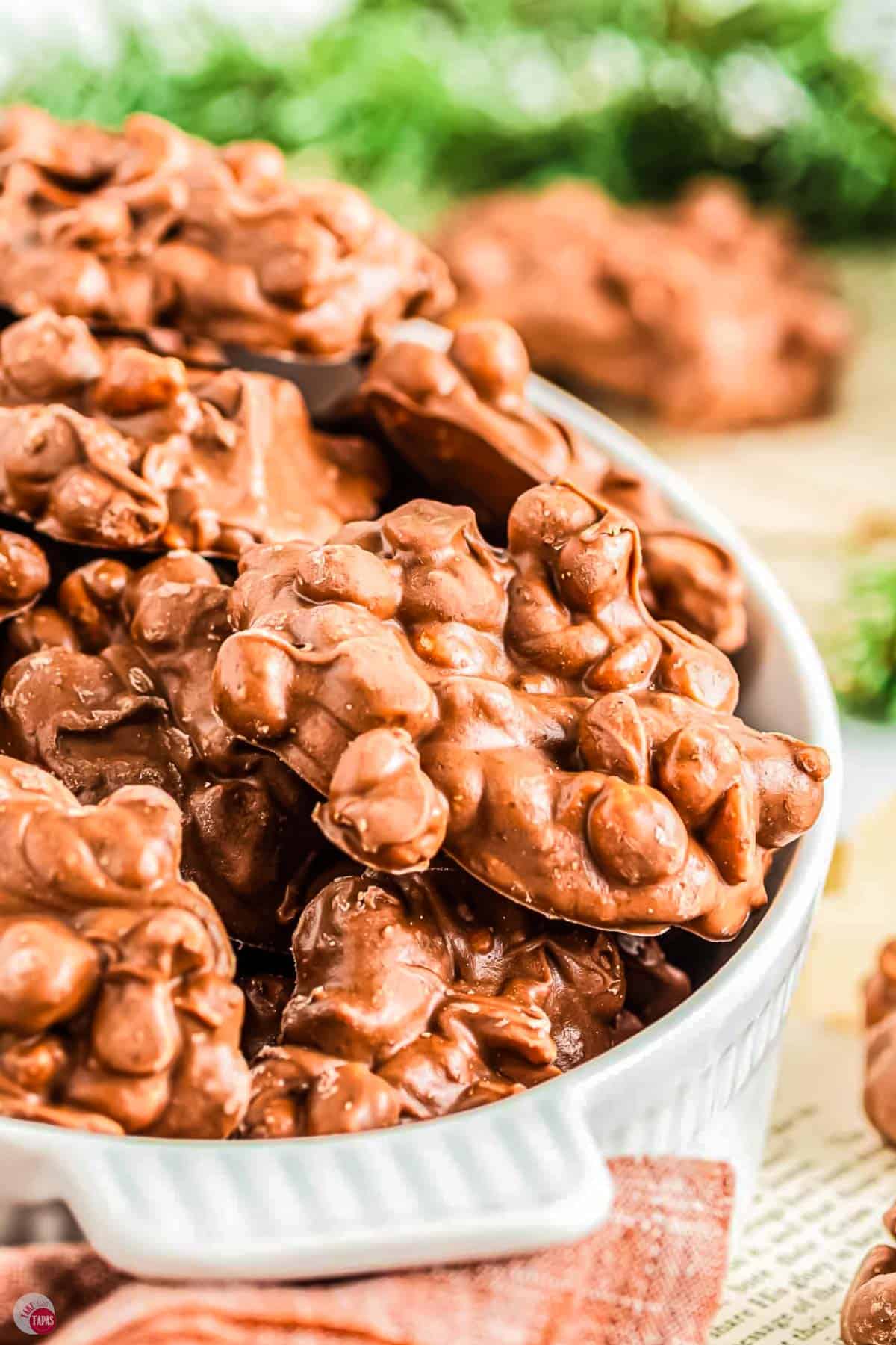 close up of white bowl with chocolate peanut clusters