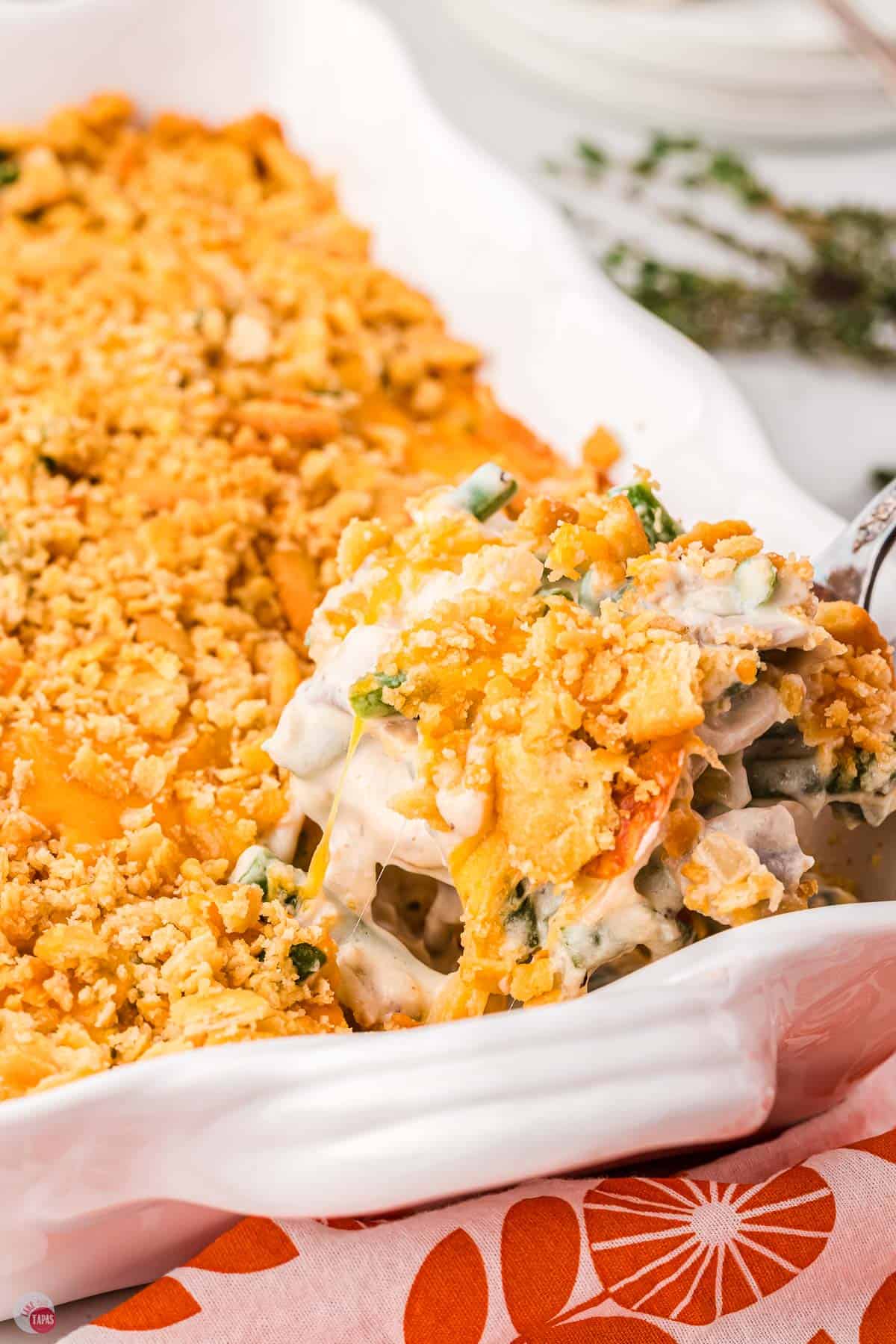 spoon scooping casserole out of a white dish
