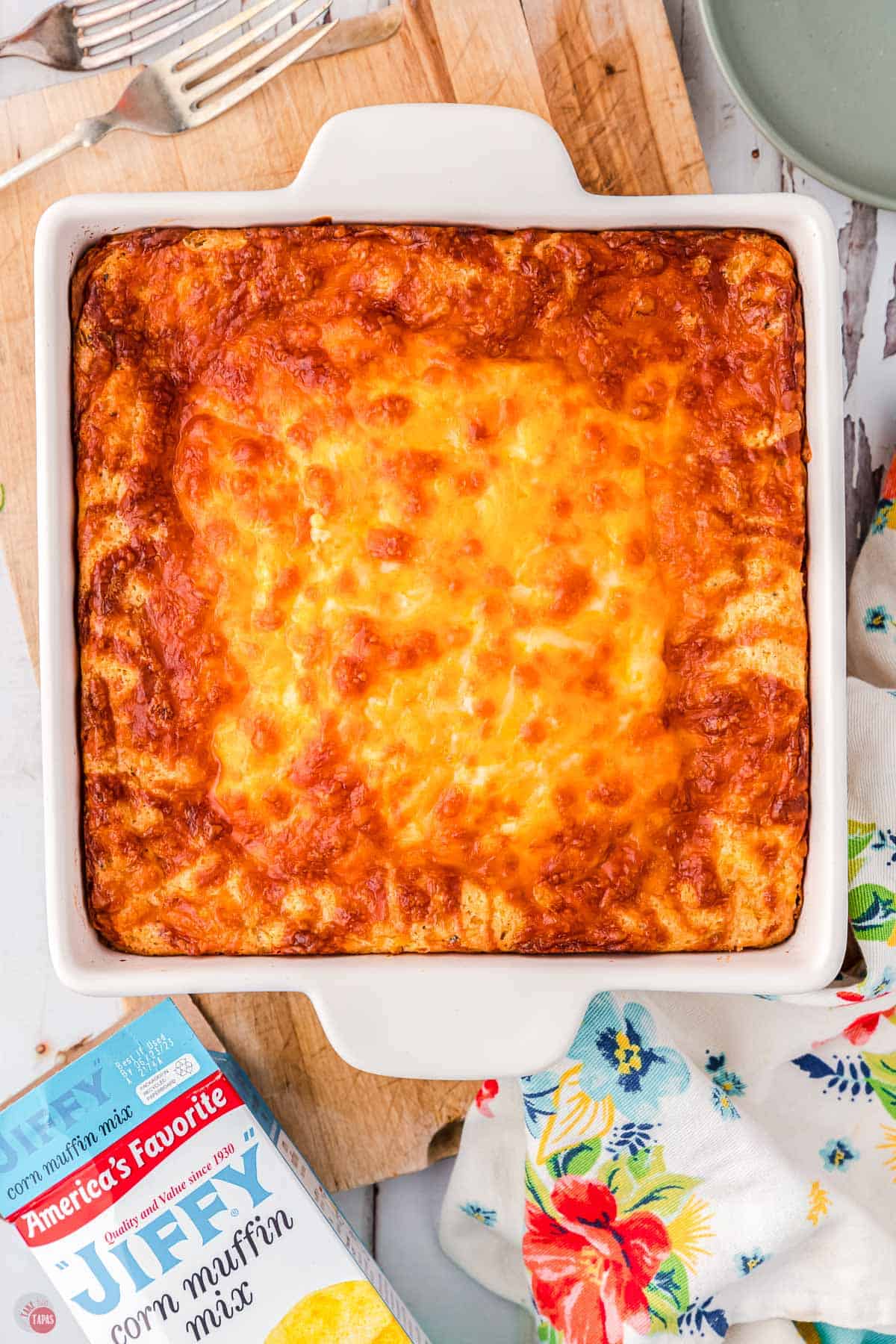 cheesy baked corn casserole in a white dish