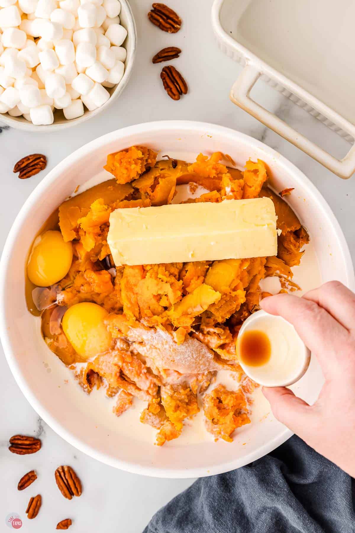 white bowl with cooked sweet potatoes, butter, eggs, and vanilla in it