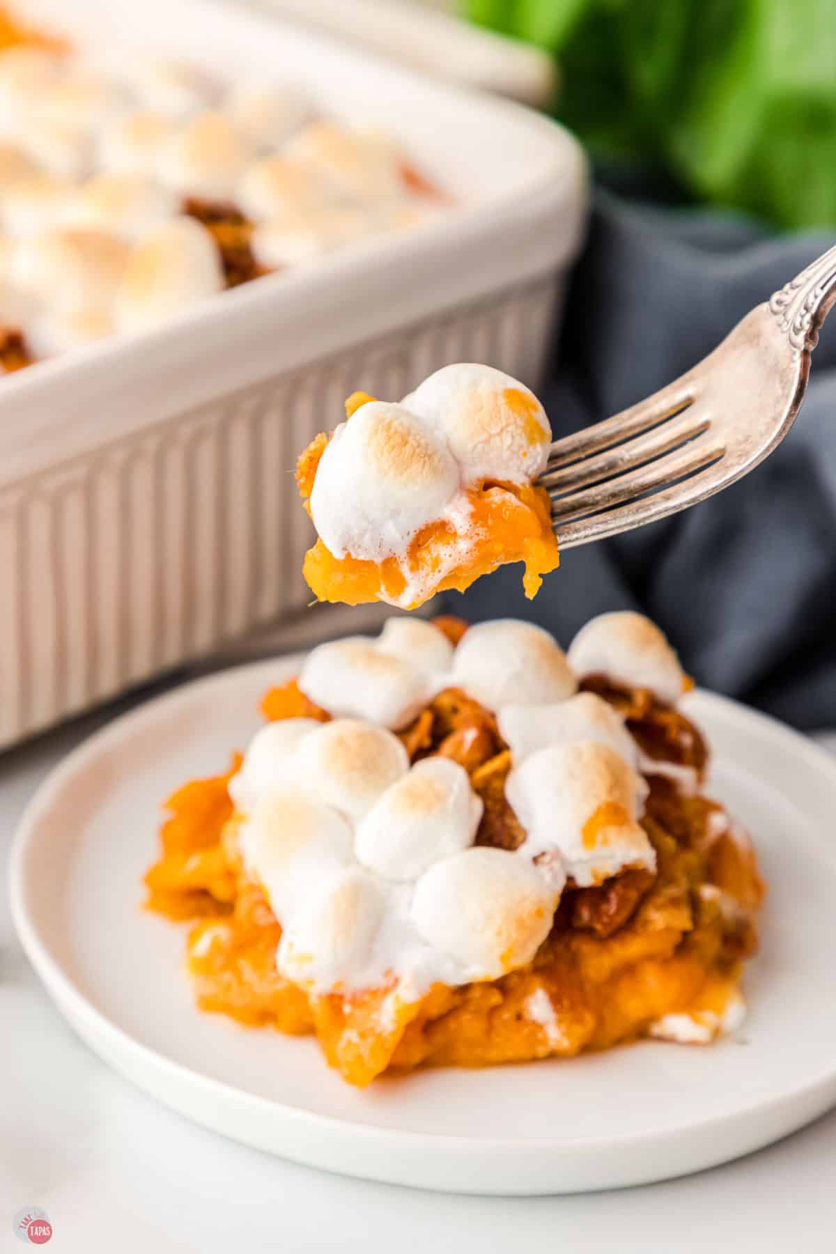 fork with a bite of casserole and two marshmallows on it