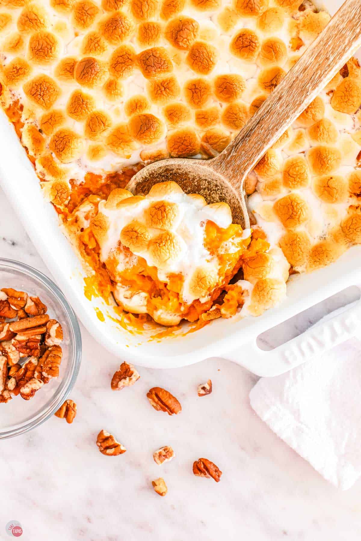 spoon scooping casserole out of a white dish