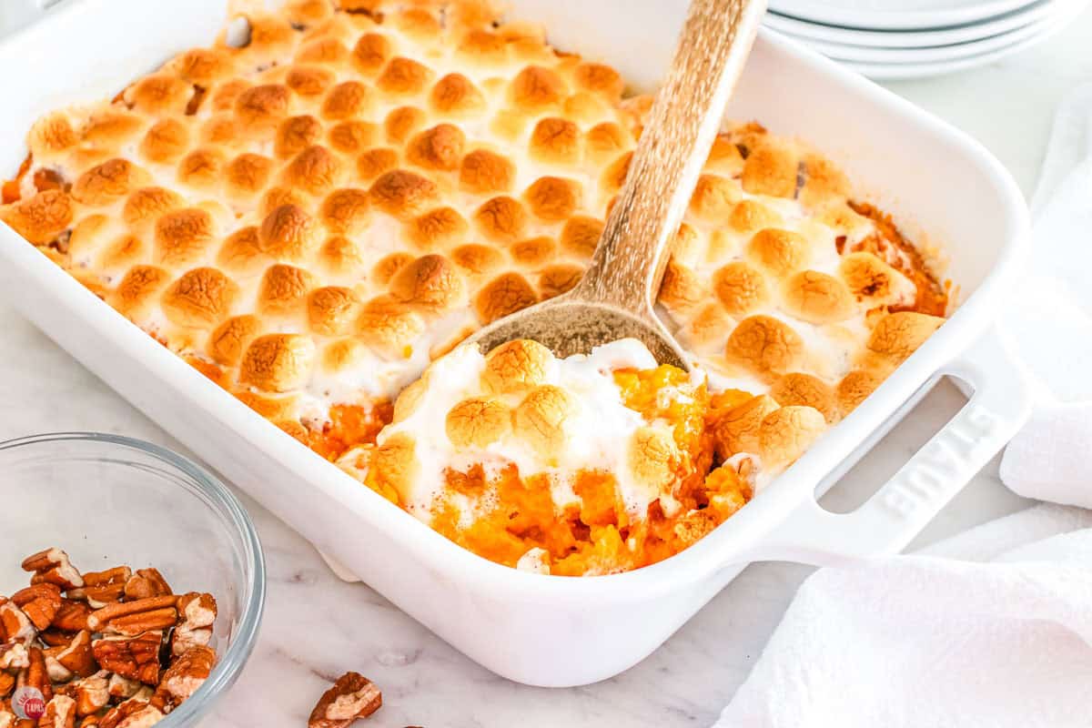 dish of sweet potatoes with marshmallows with a spoon in it