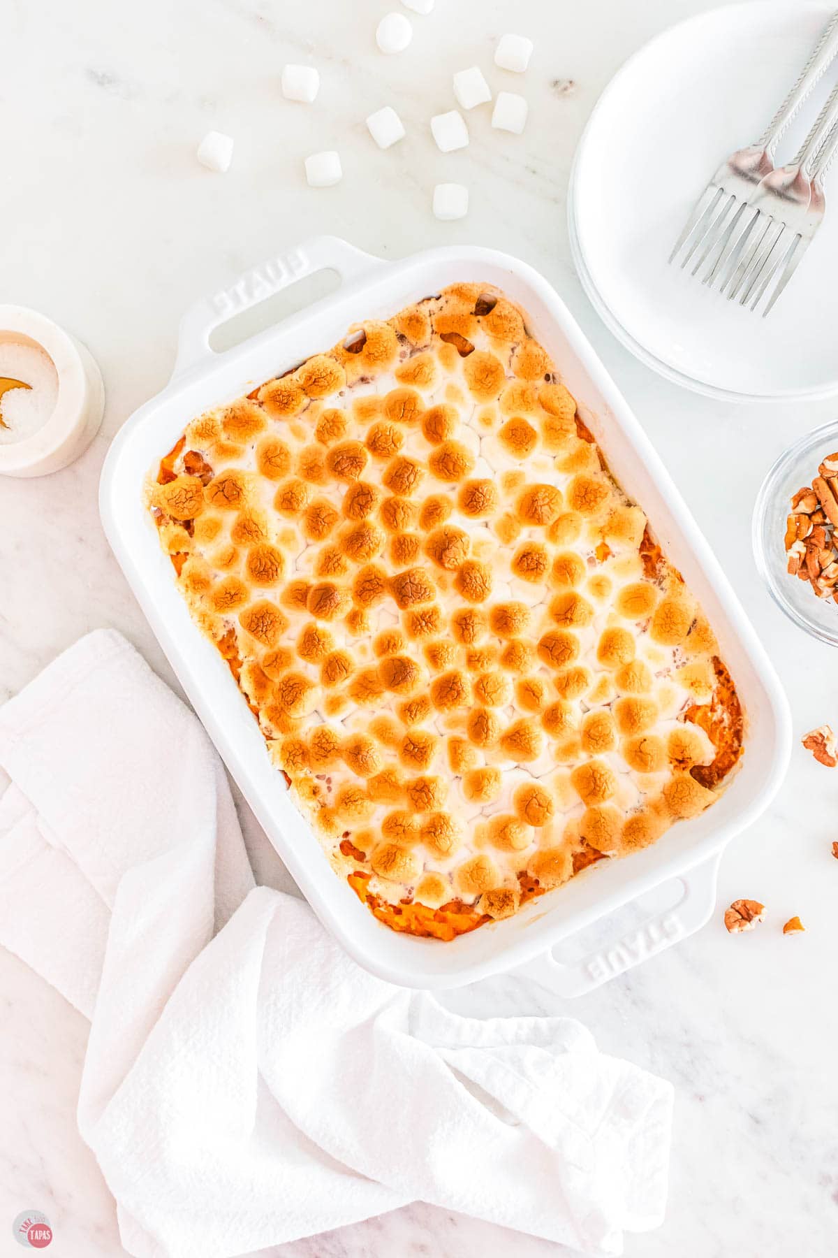 overhead picture of old fashioned sweet potato casserole in a white dish with a napkin next to it