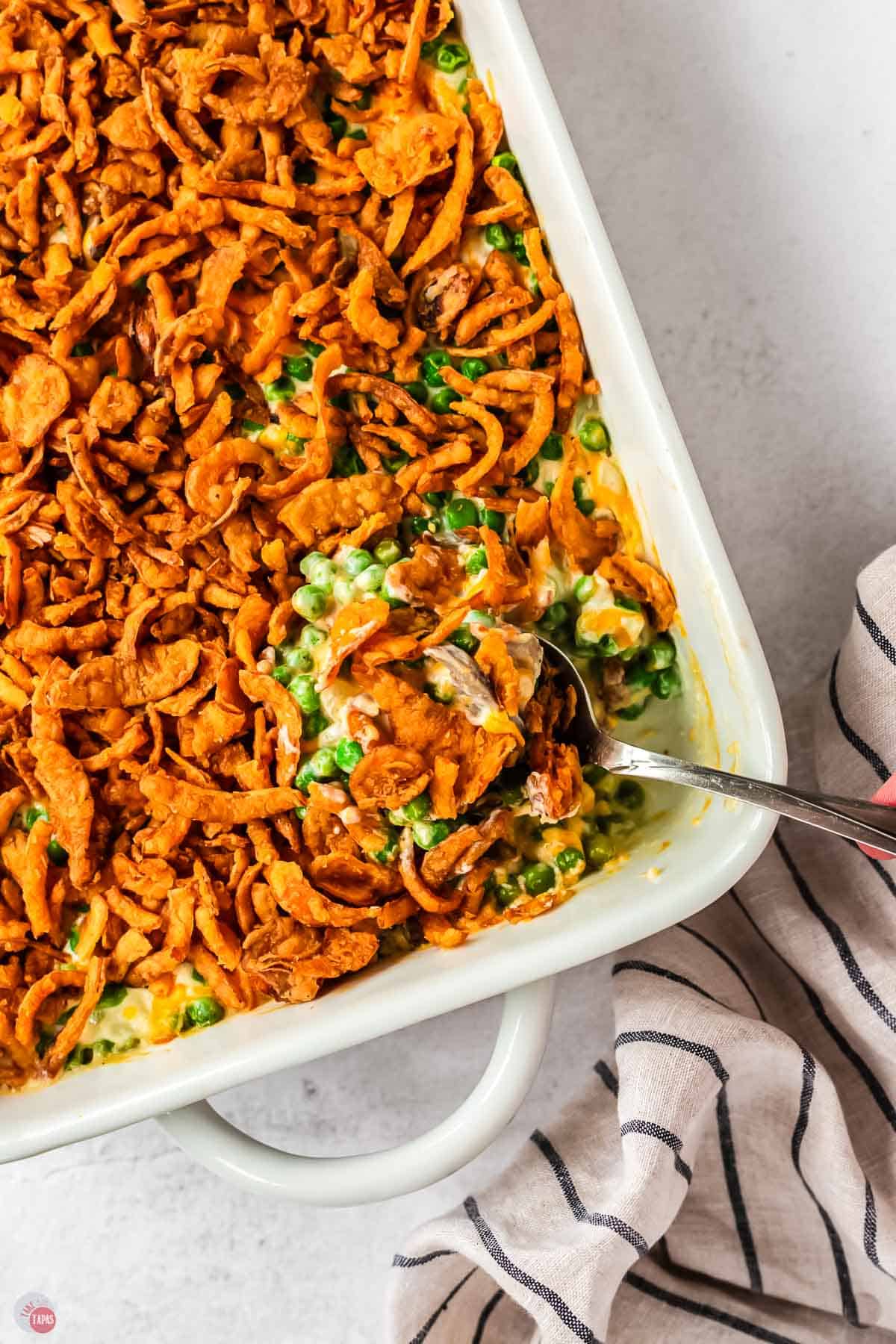 overhead picture of spoon scooping casserole out of a white dish