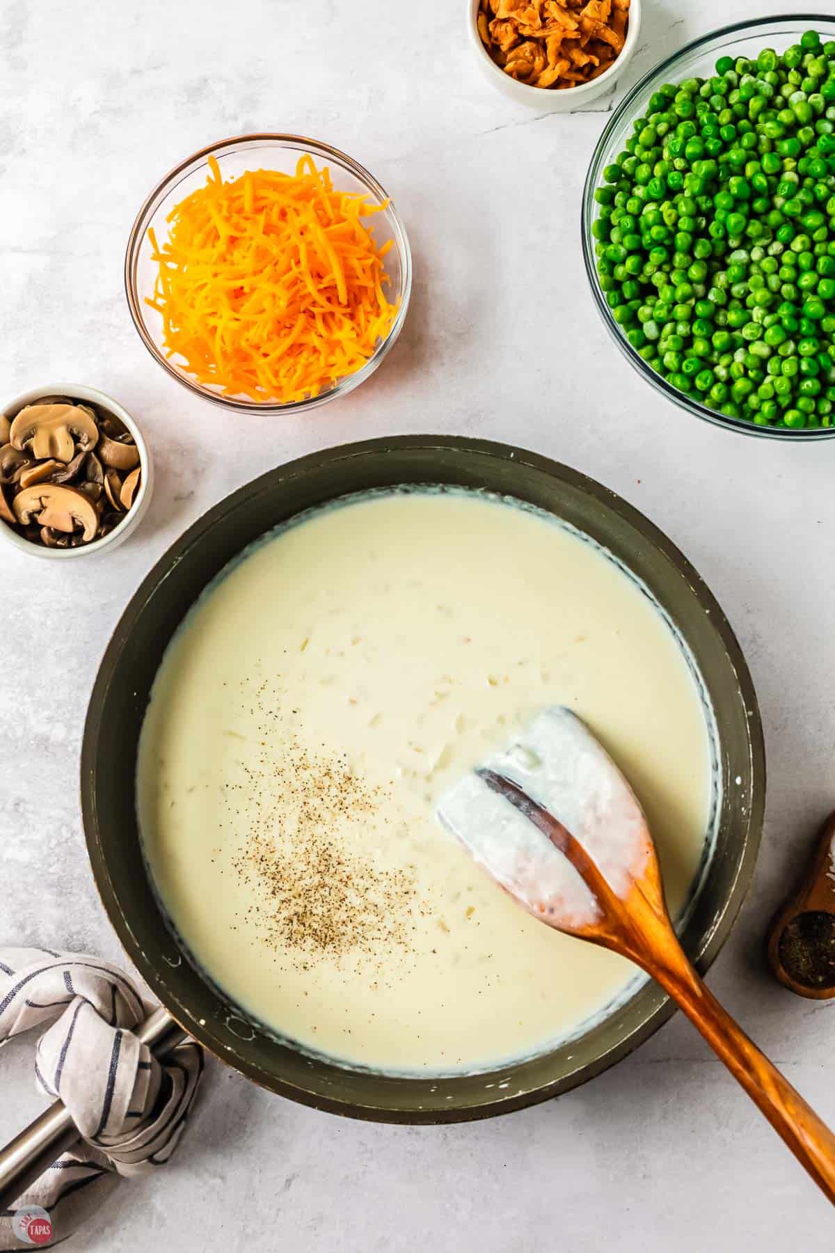 skillet with roux and a wood spoon with a line in the roux scraped off