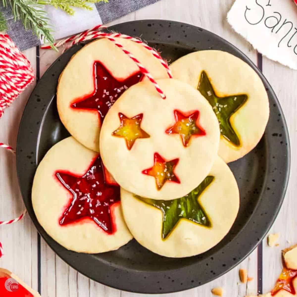 black plate with 5 stained glass cookies on it and a note to santa