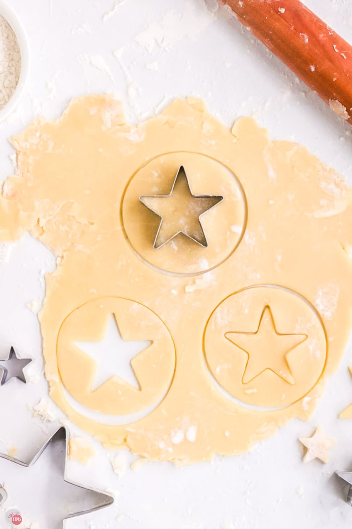cookie dough rolled out and being cut into stars with a cookie cutter