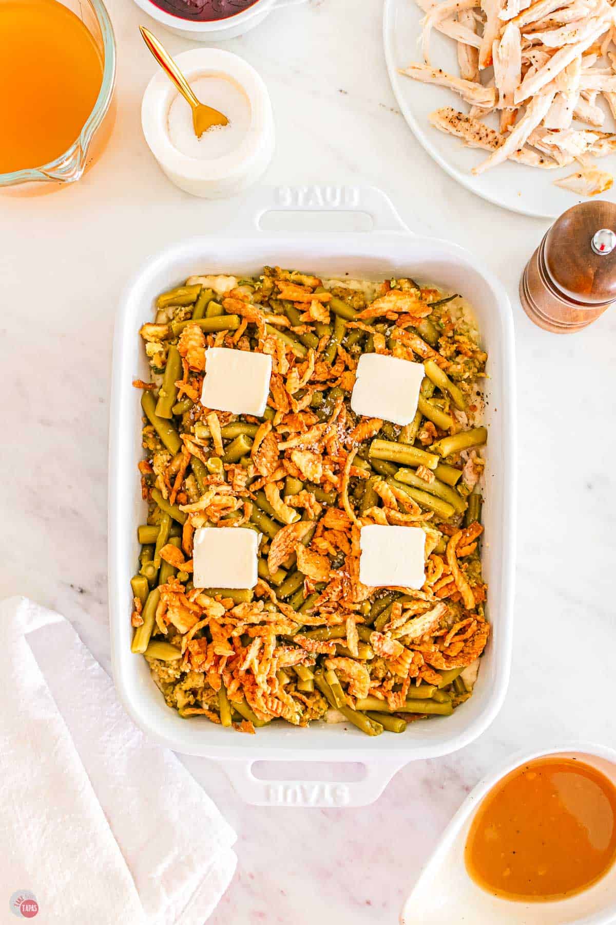 leftovers casserole in a dish with 4 pats of butter on top
