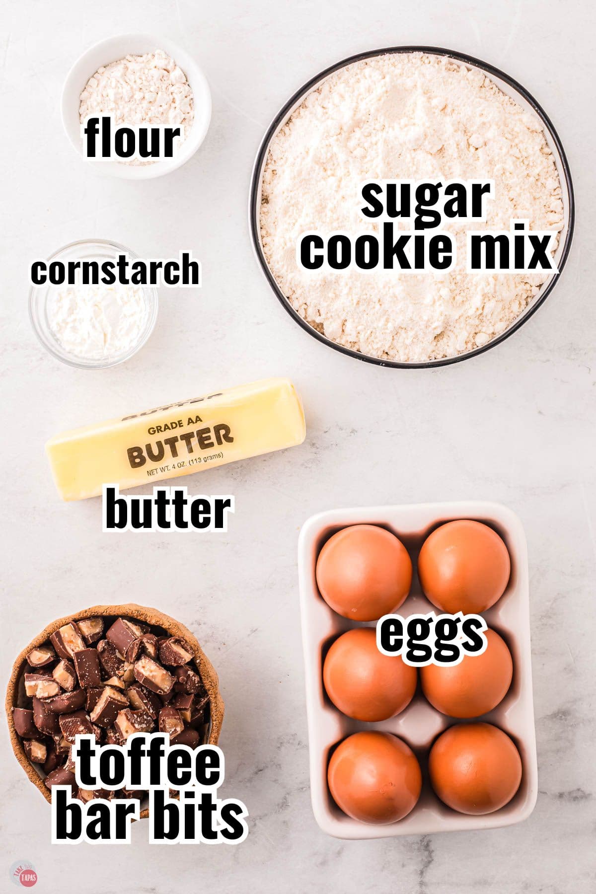 ingredients for a cookie recipe in individual bowls with text overlay labeling them