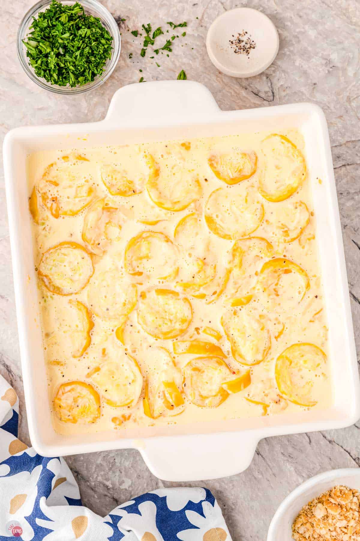 squash mixture in a square white dish with a flower napkin next to it