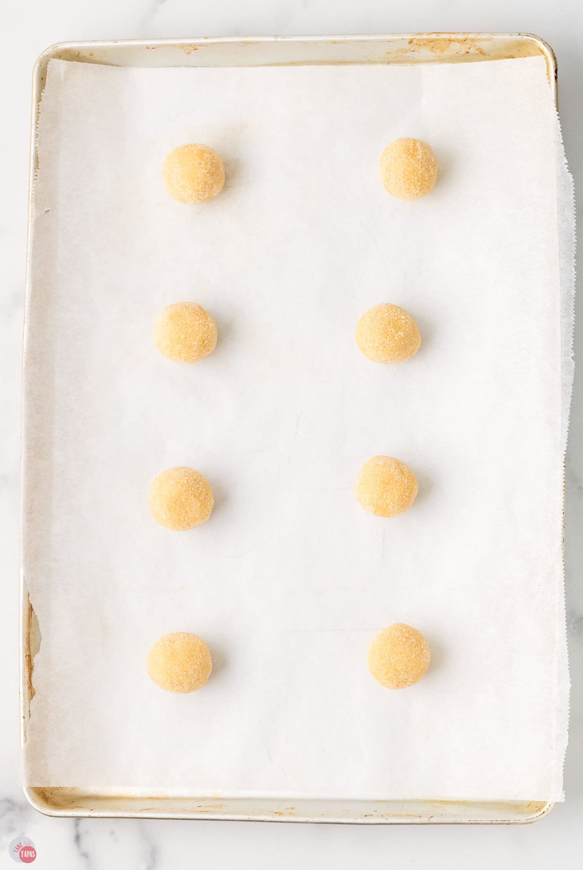 cookie dough balls on a baking sheet with parchment paper