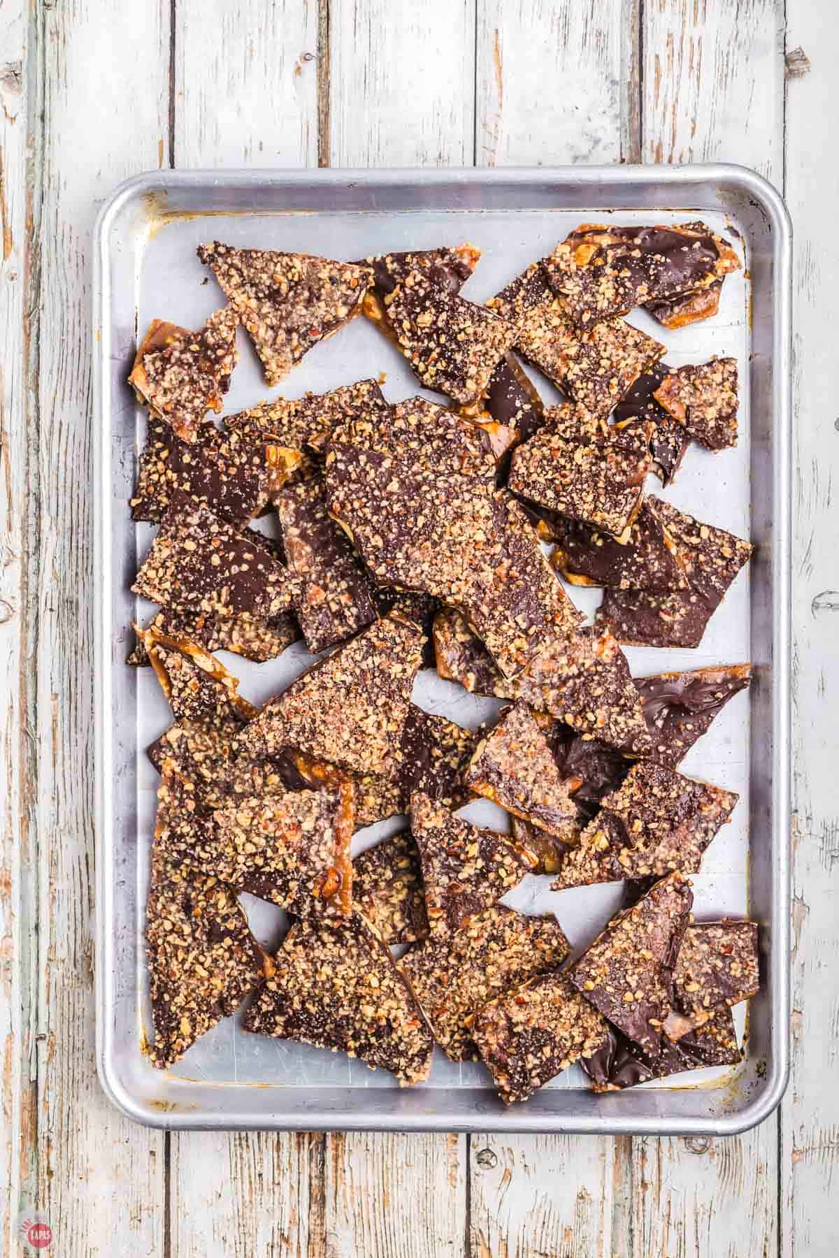 almond roca candy broken into pieces on a baking sheet