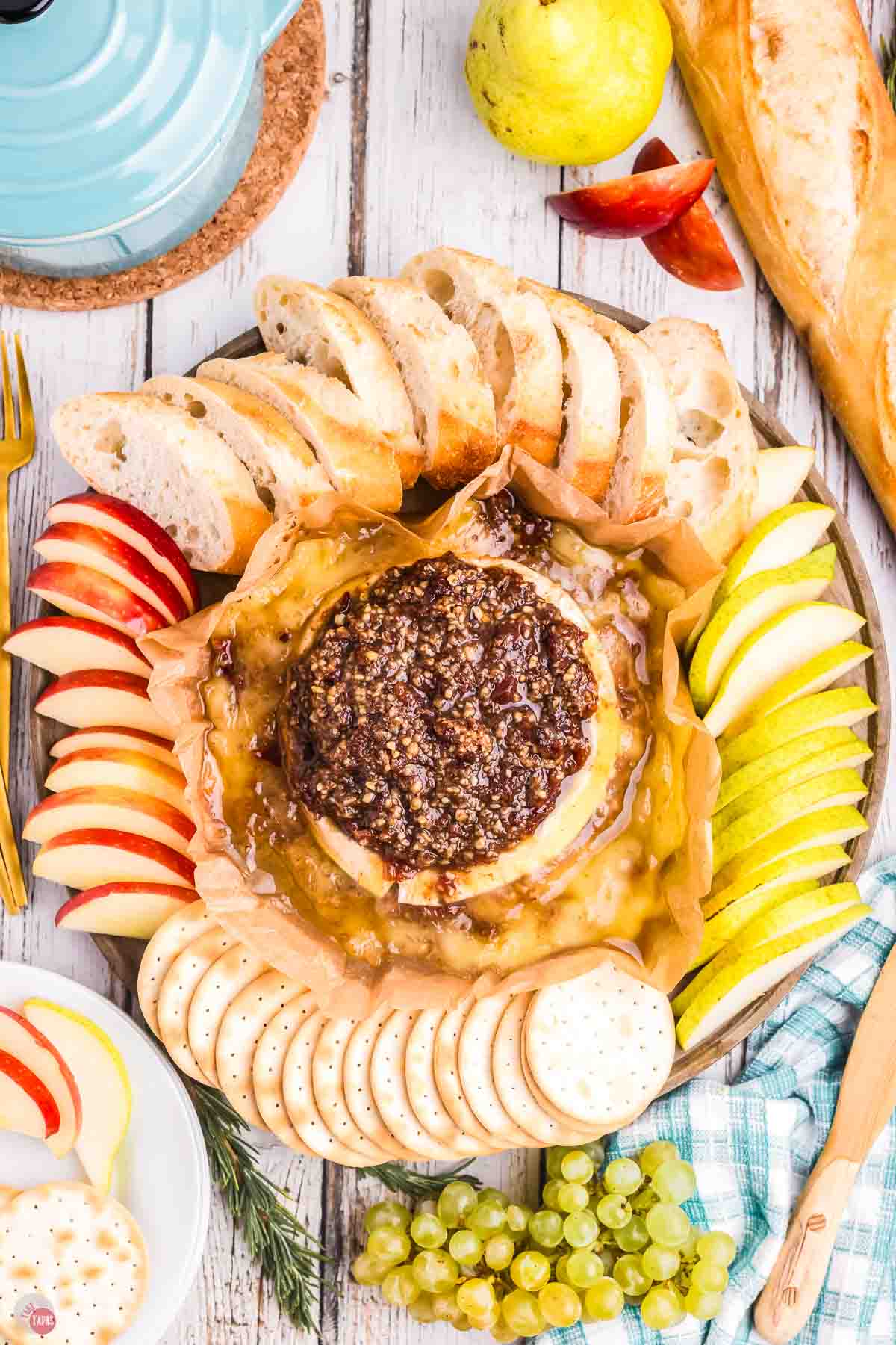 platter with baked brie, fruit slices and crackers