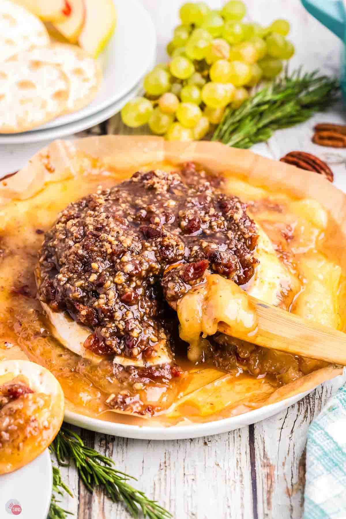 baked cheese with jam and a wood spreader