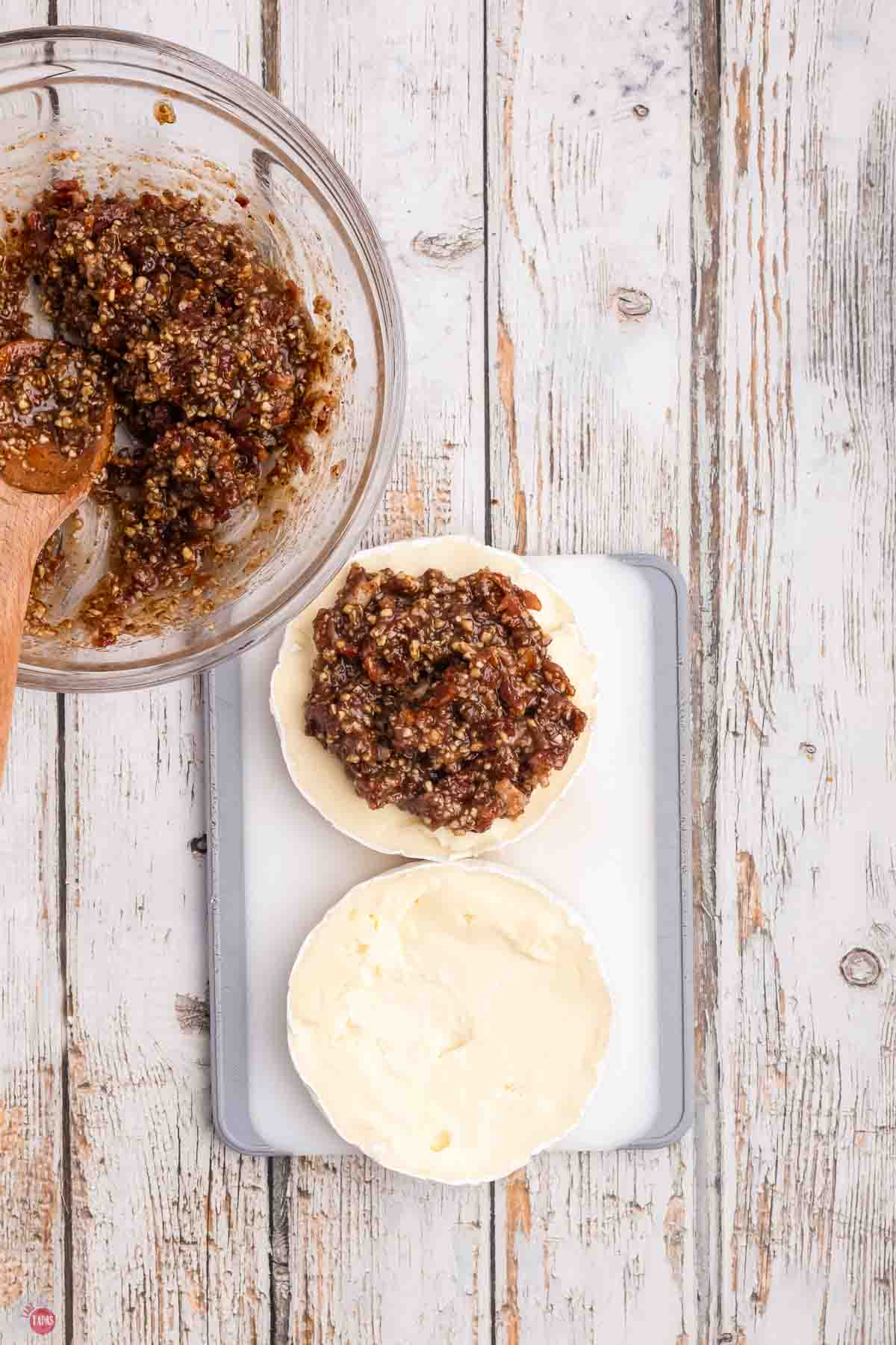 wheel of brie cheese cut in half with bacon jam on it