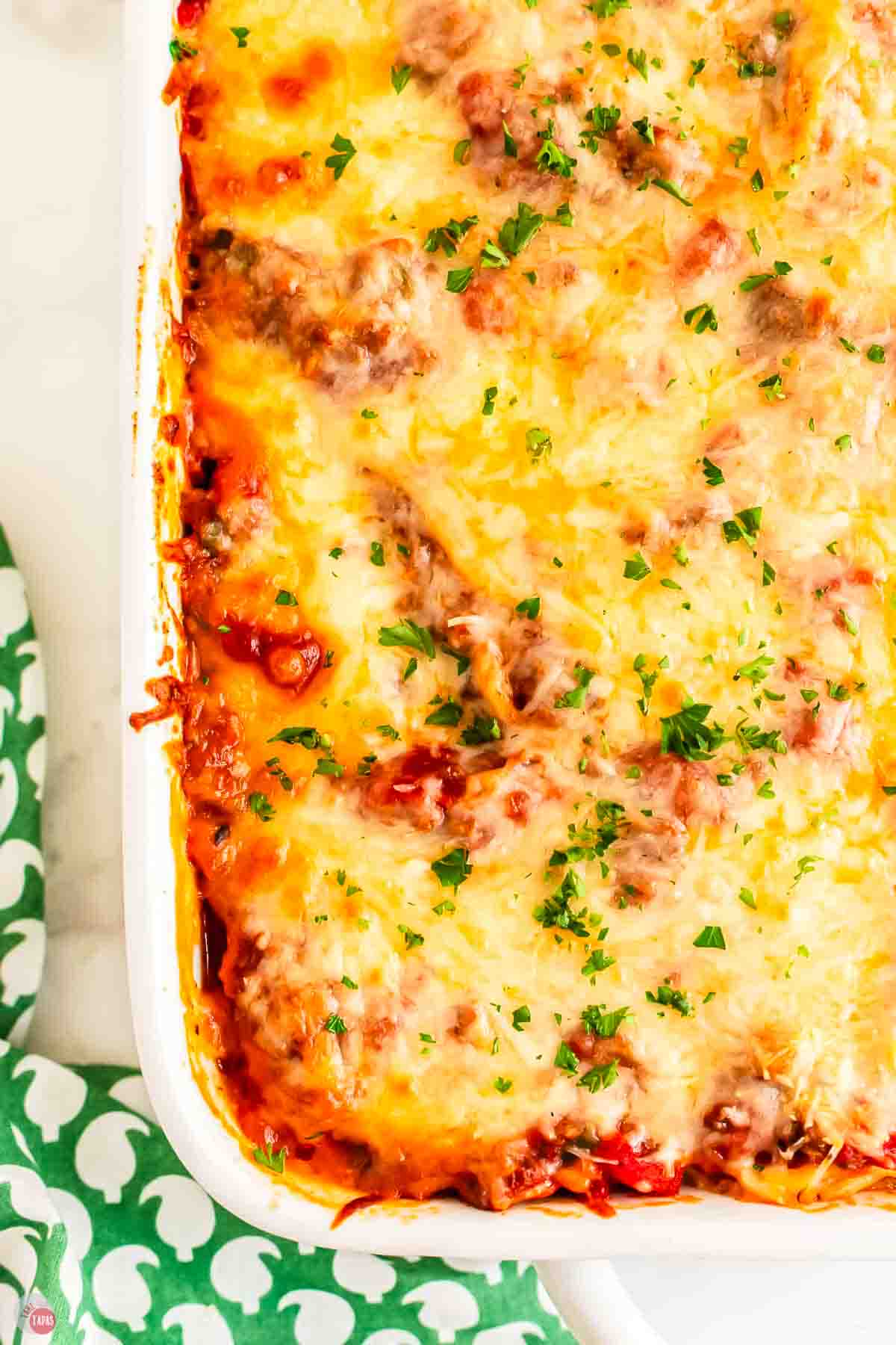 close up of baked spaghetti casserole in a white dish